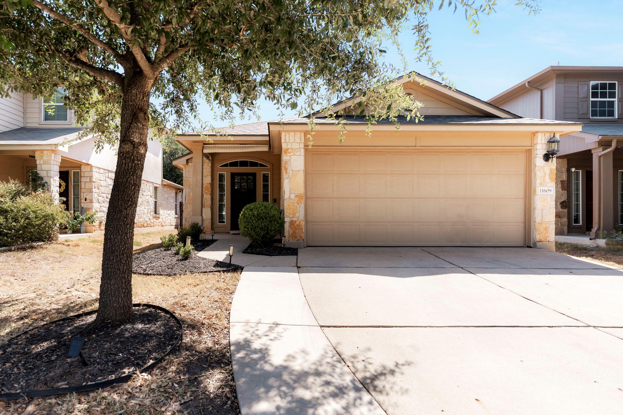 A spacious driveway and attached garage accent th