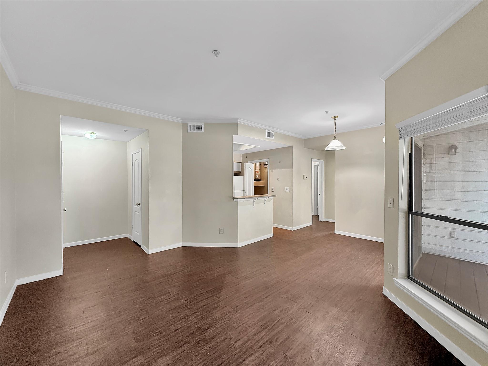 Rich wood-look flooring and crown molding define 