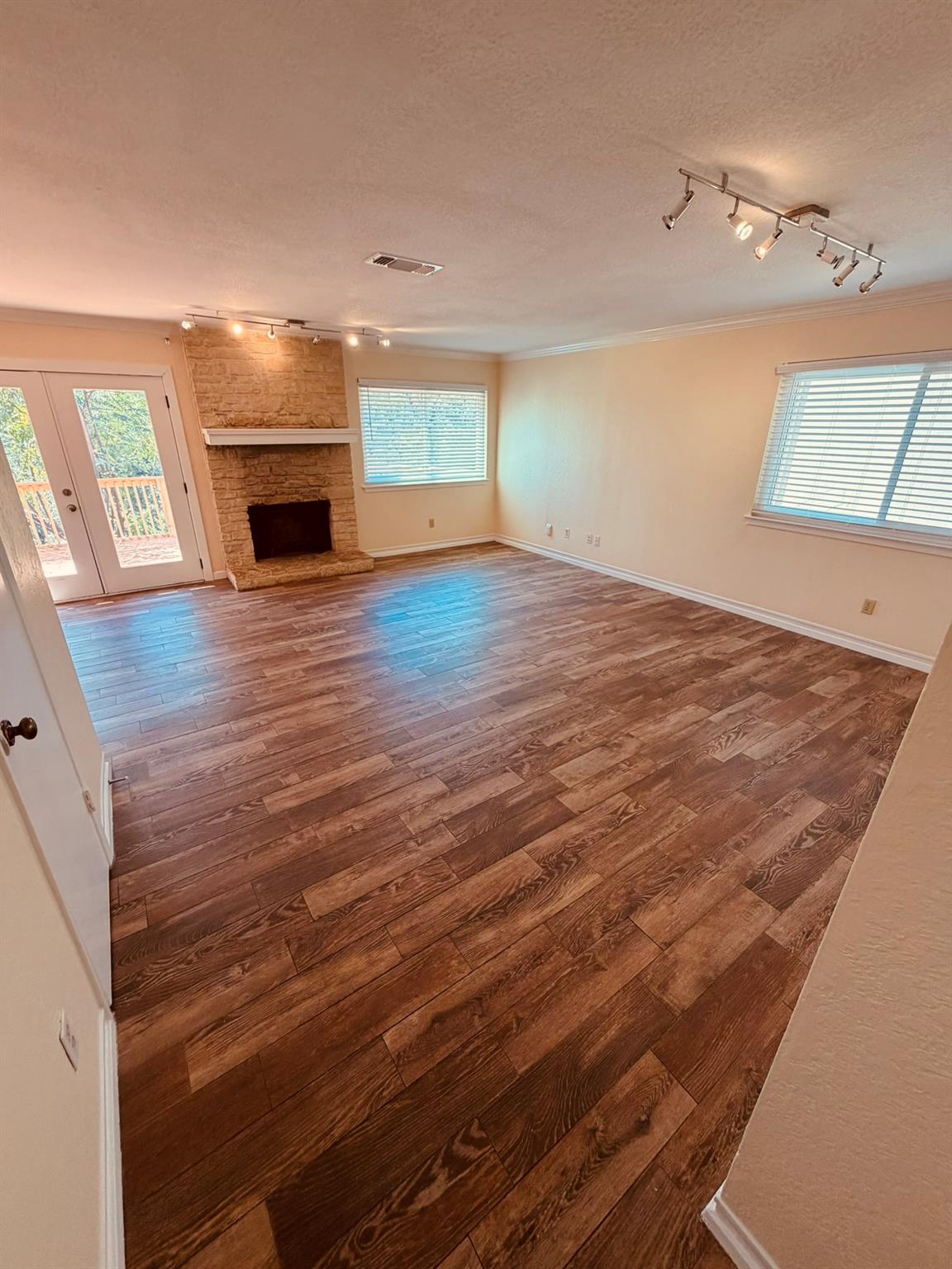 Rich wood-look flooring anchors a spacious living