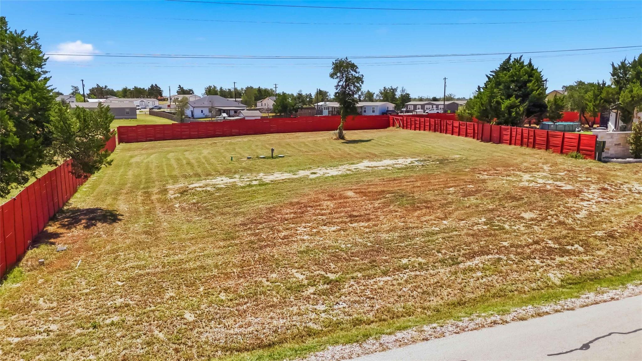A spacious, cleared lot comes fully enclosed by e