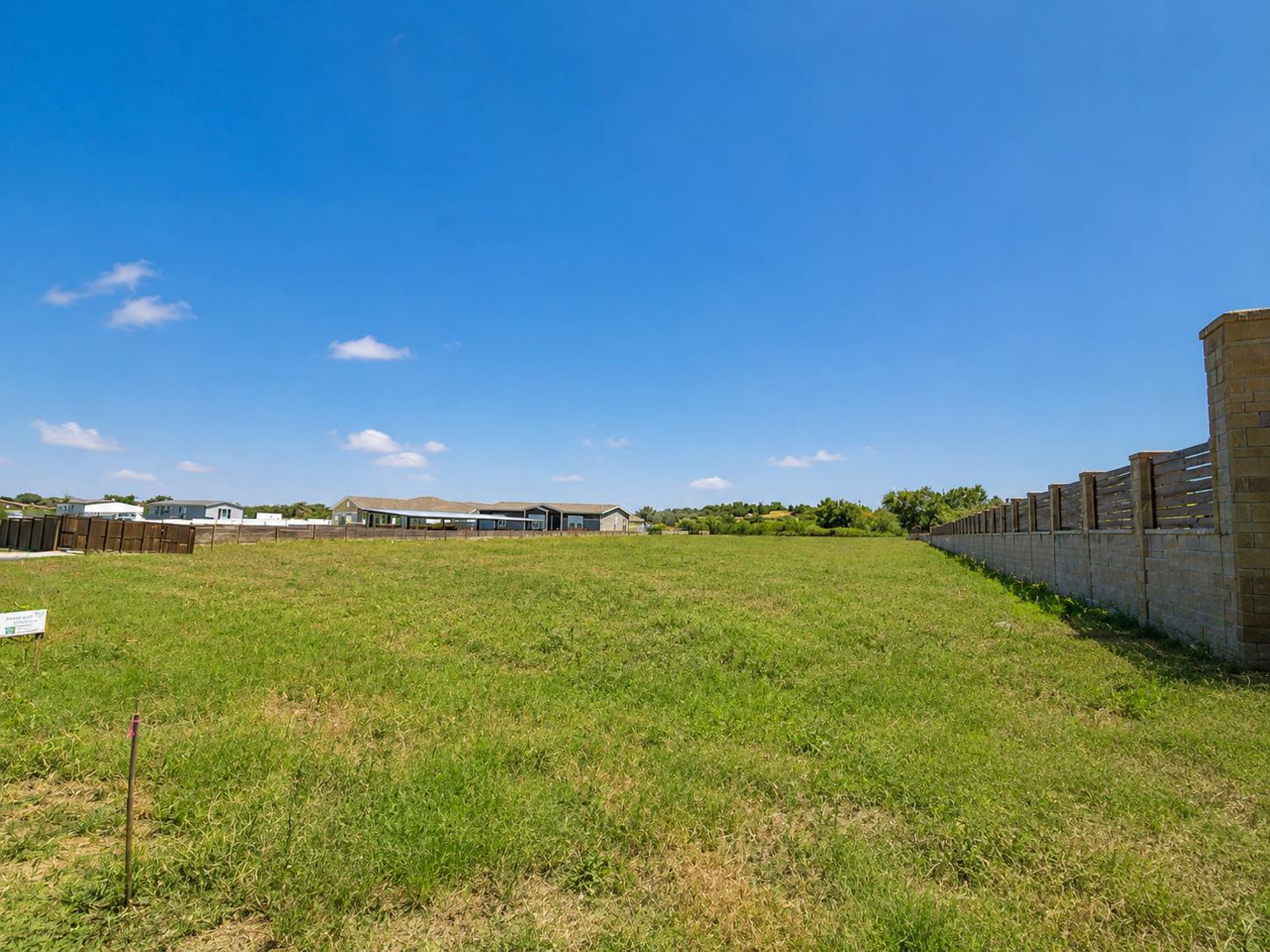 An expansive green lawn stretches under a clear b
