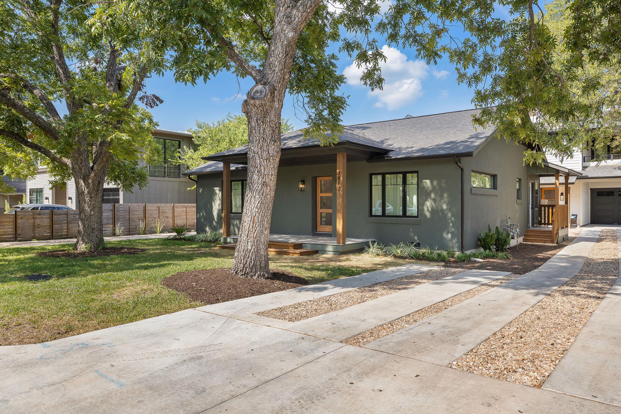 Mature trees shade a welcoming front porch and co