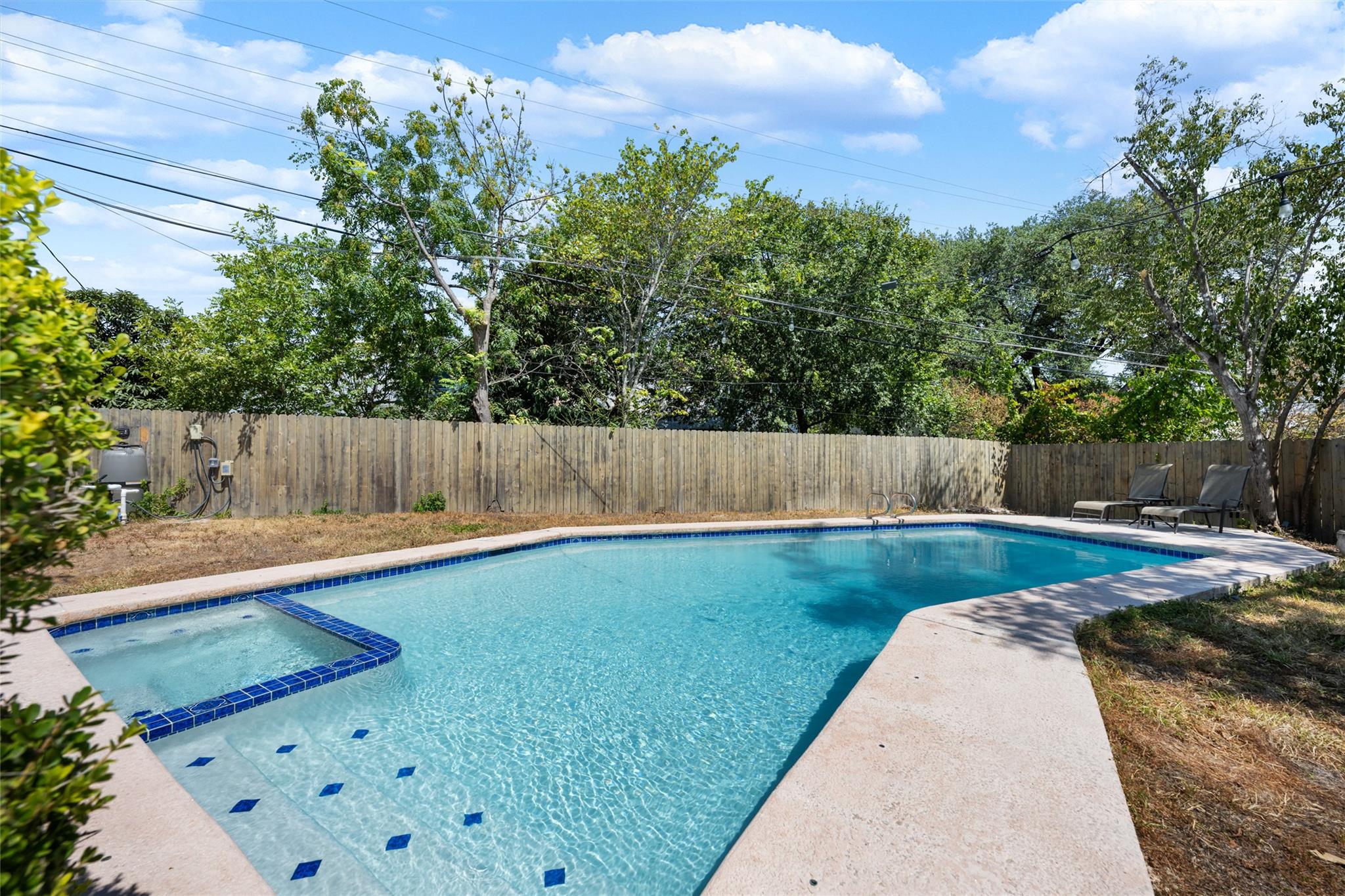 Mature trees frame a private swimming pool with i