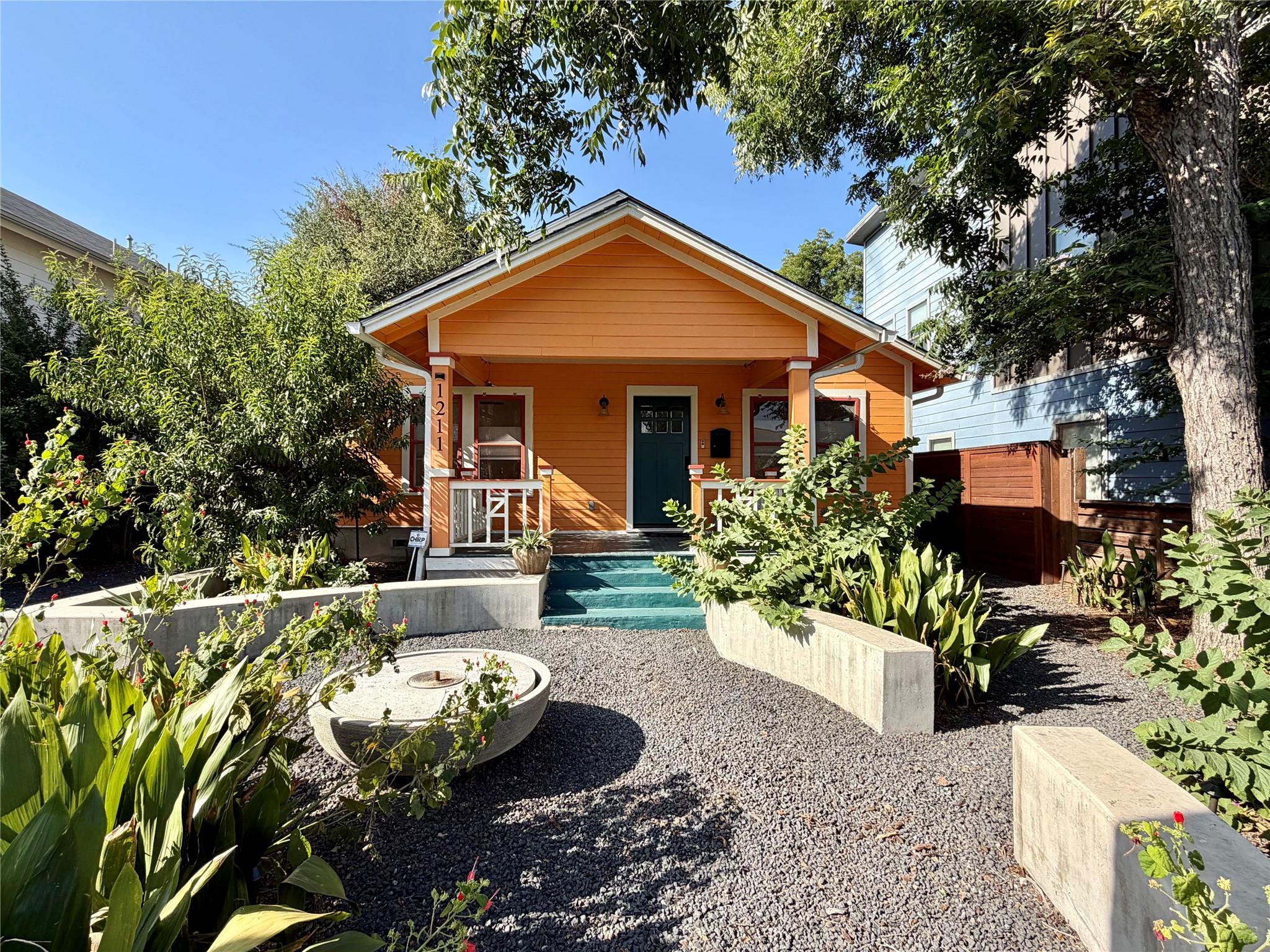 Mature trees frame a welcoming front porch and lo