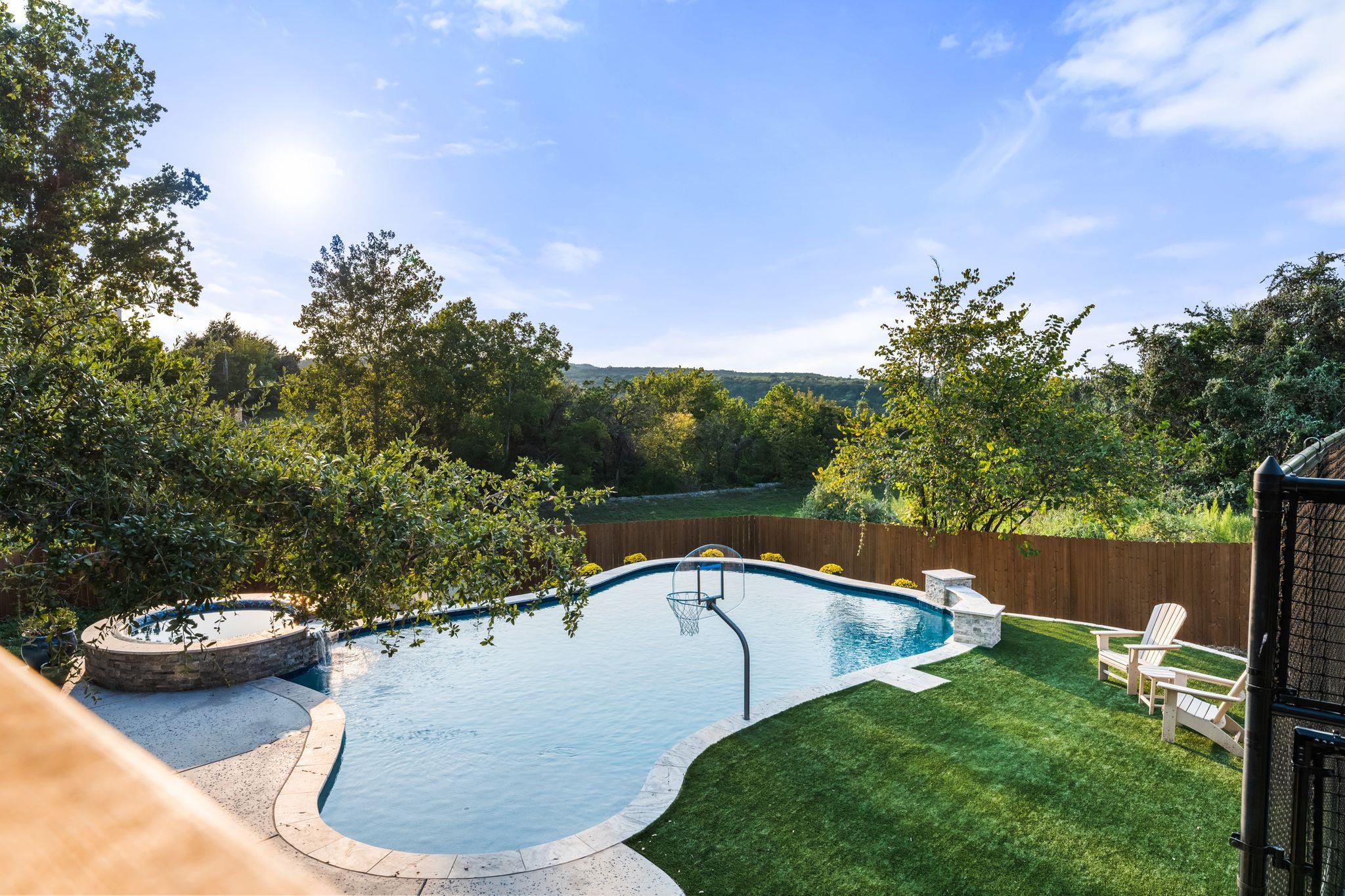 Lush green lawns and tall trees surround a refres