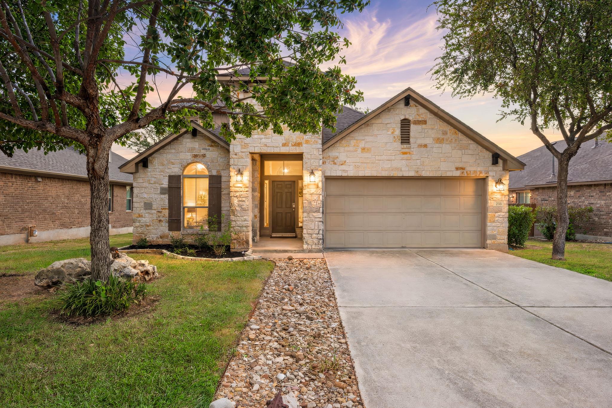 Textured stone veneer and a concrete driveway lea