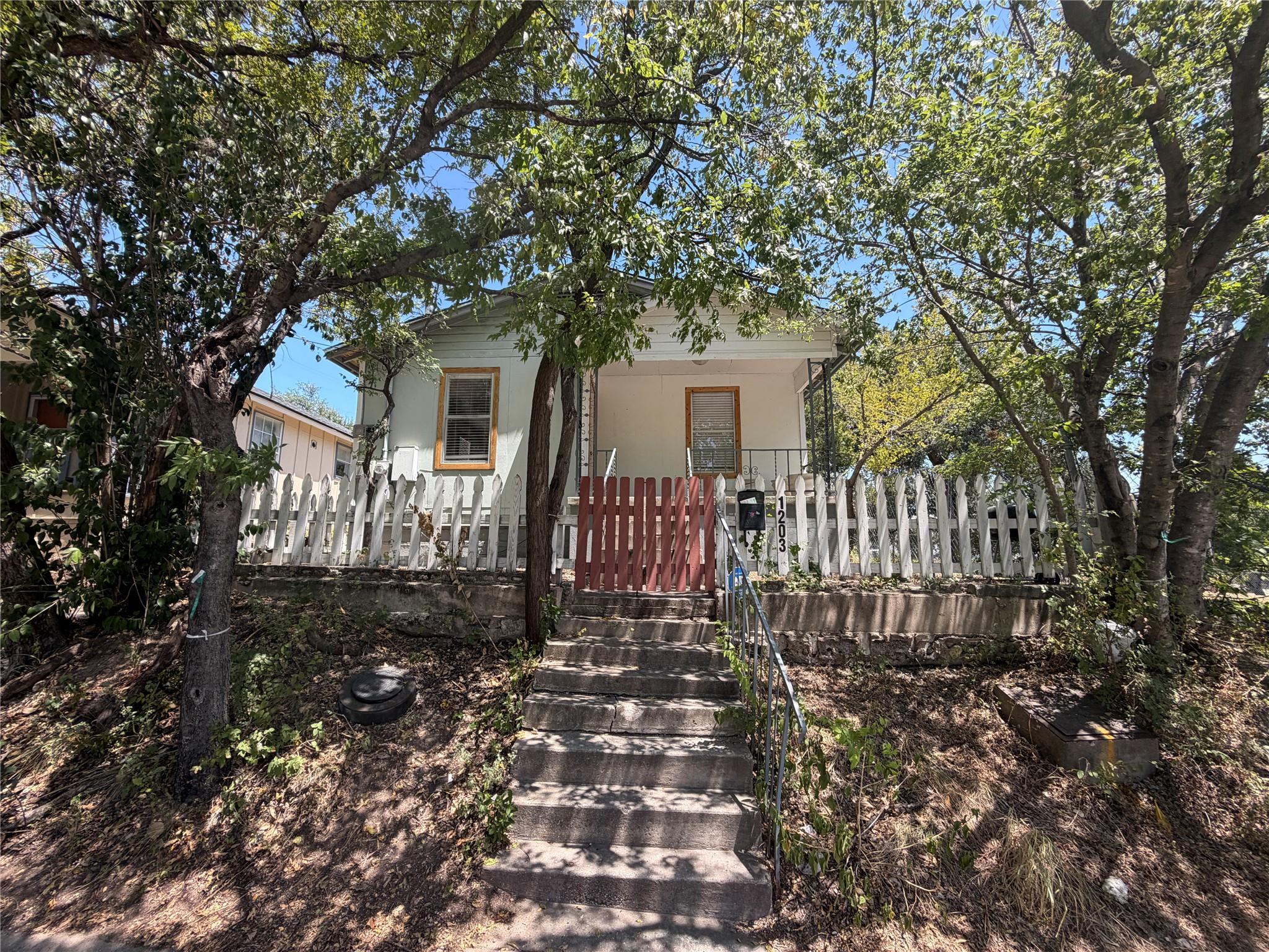Mature trees shade a welcoming front porch framed