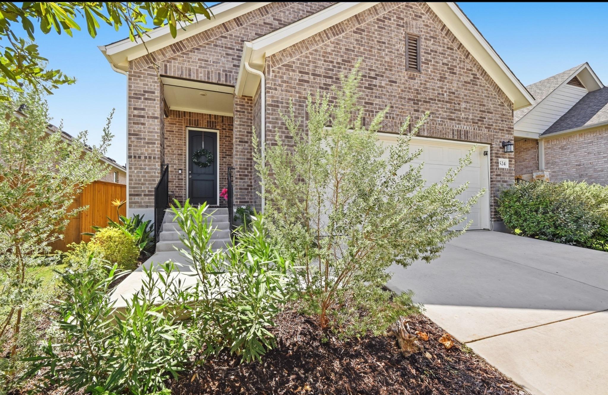 Brick cladding and a neat concrete driveway defin