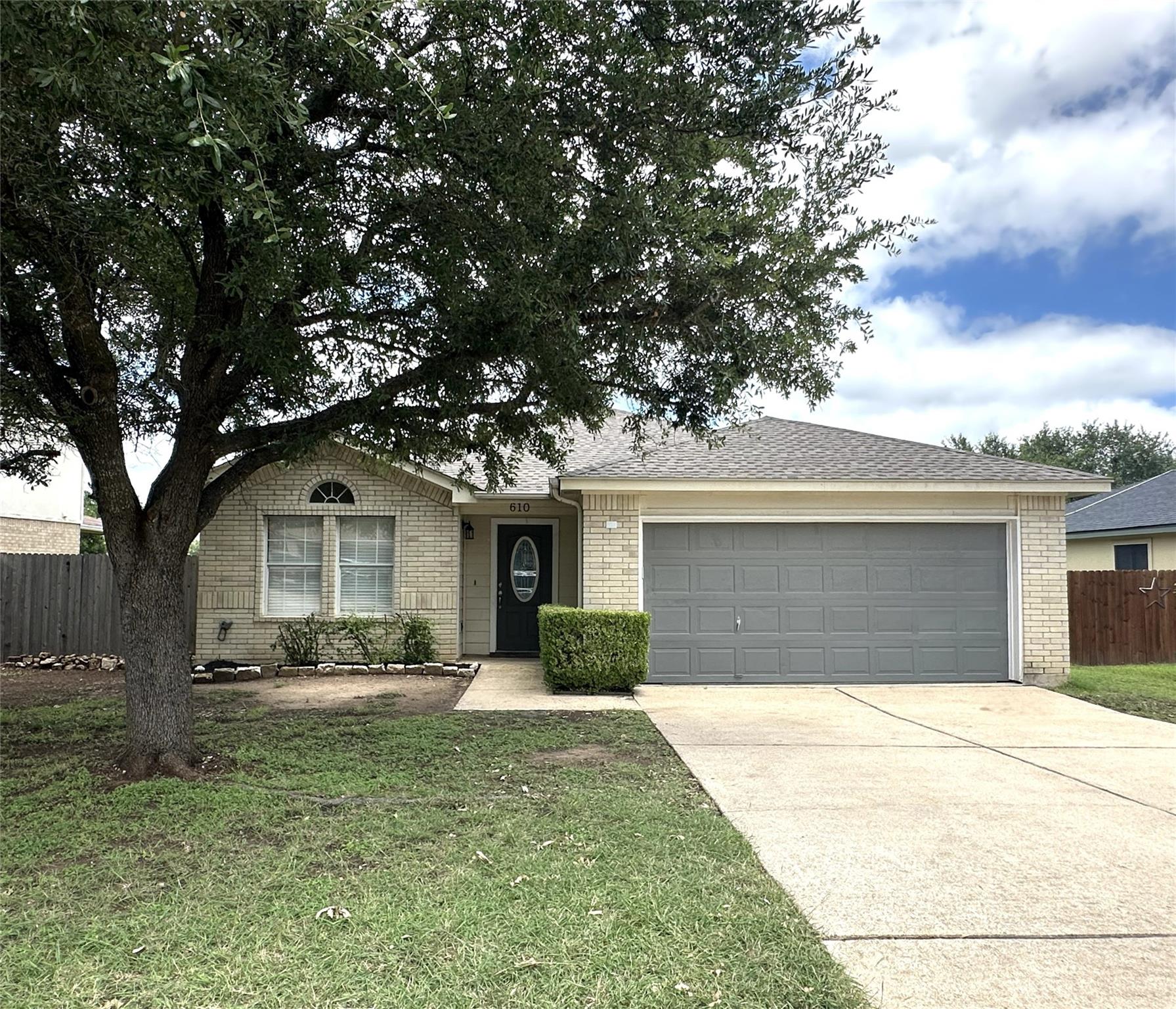 Established shade trees frame the classic brick e