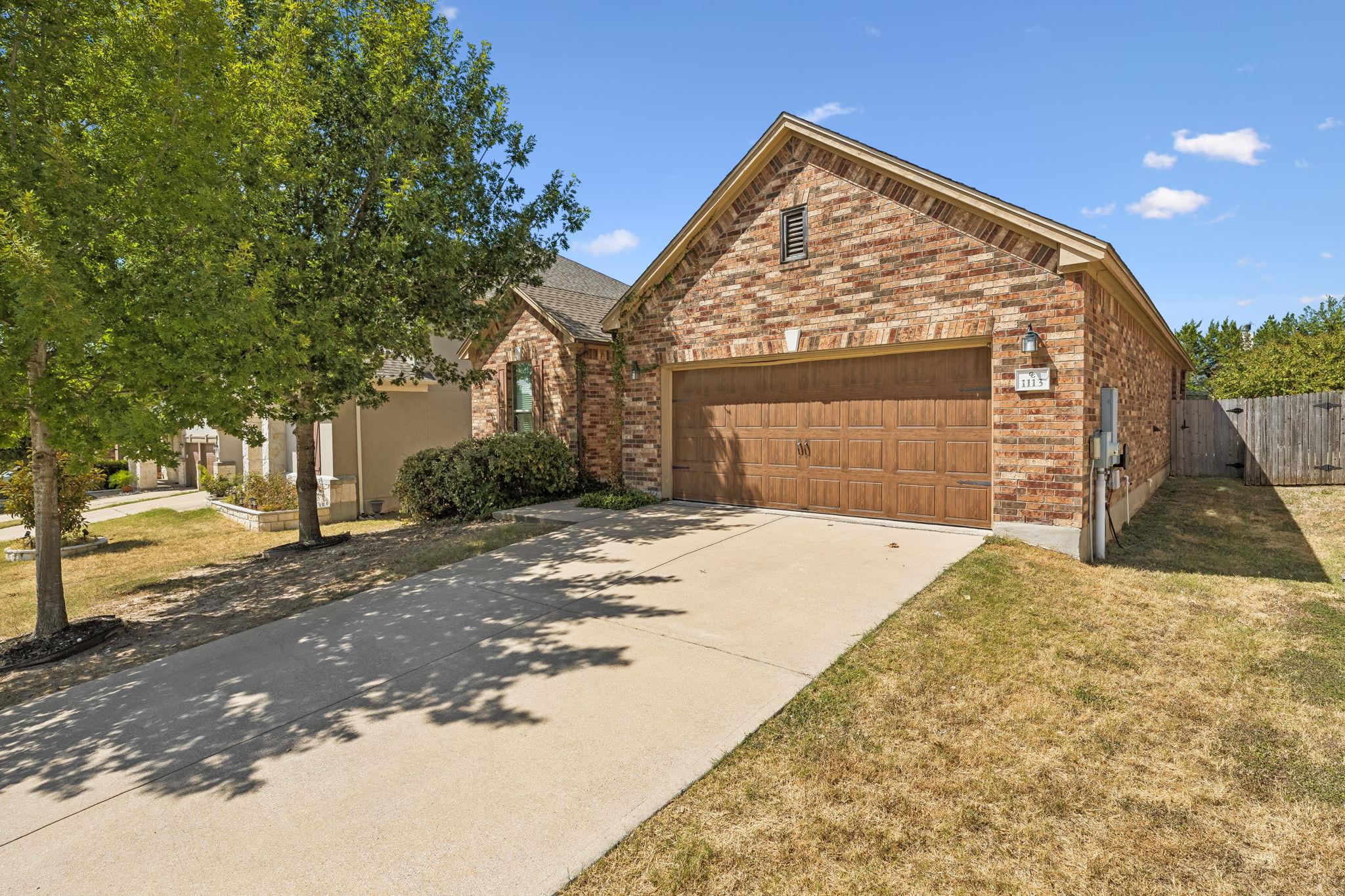 Brick exterior walls and a wide concrete driveway