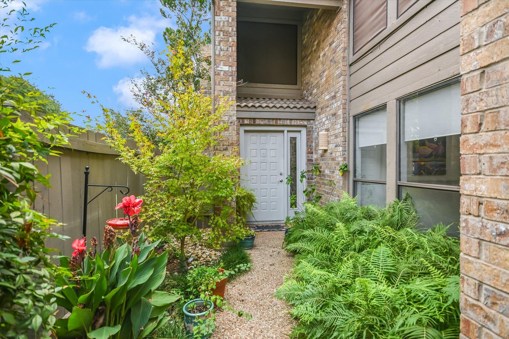 Lush landscaping frames a private brick-accented 