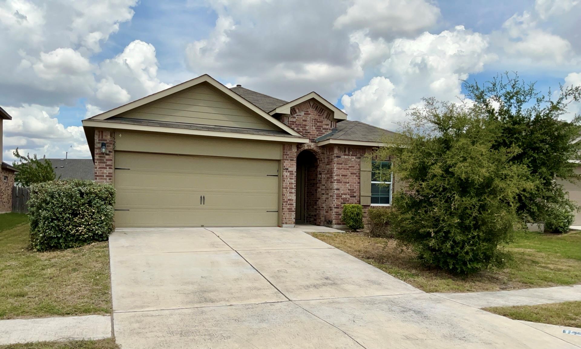 A classic brick exterior and concrete driveway le