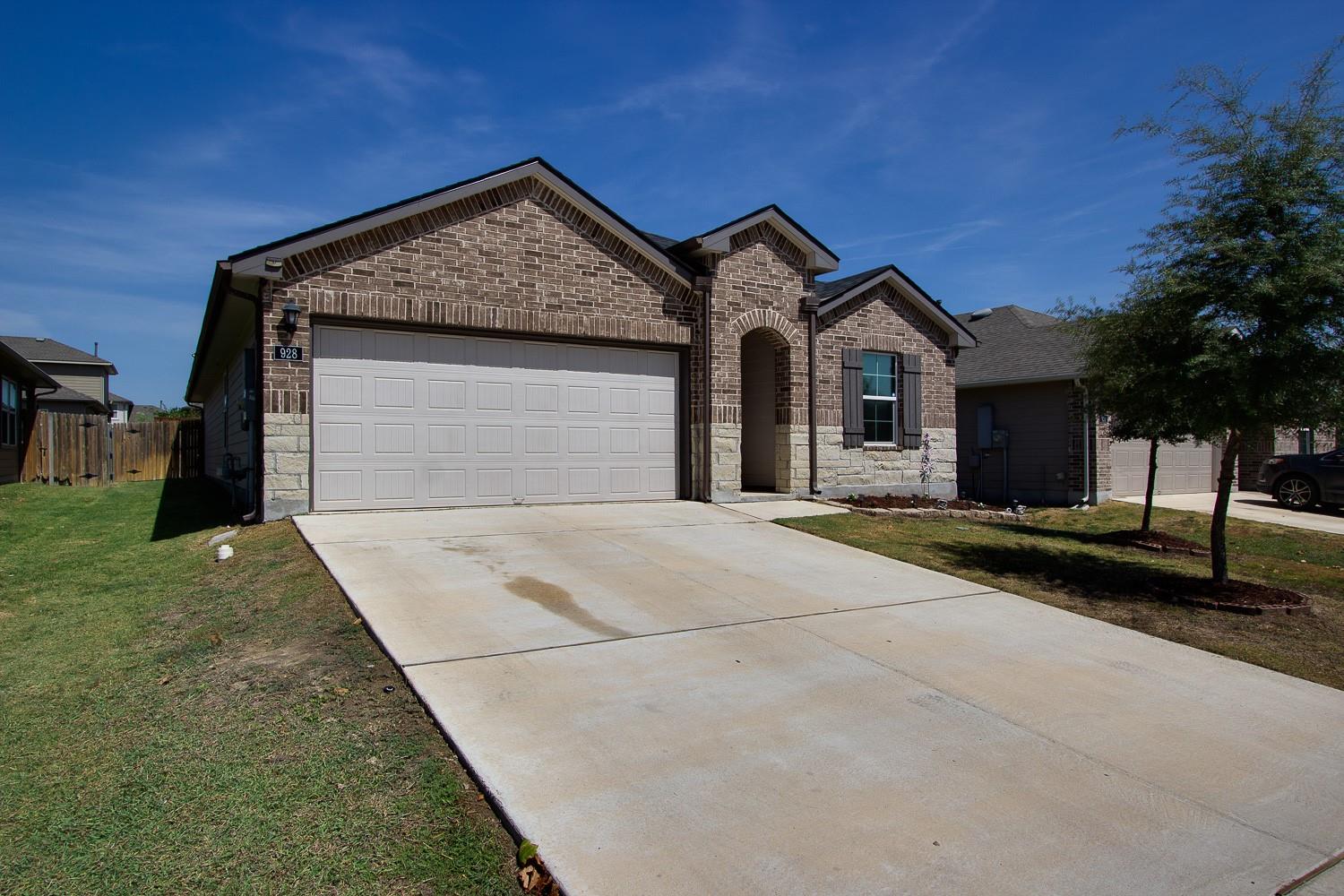 Textured brickwork and a wide concrete driveway d