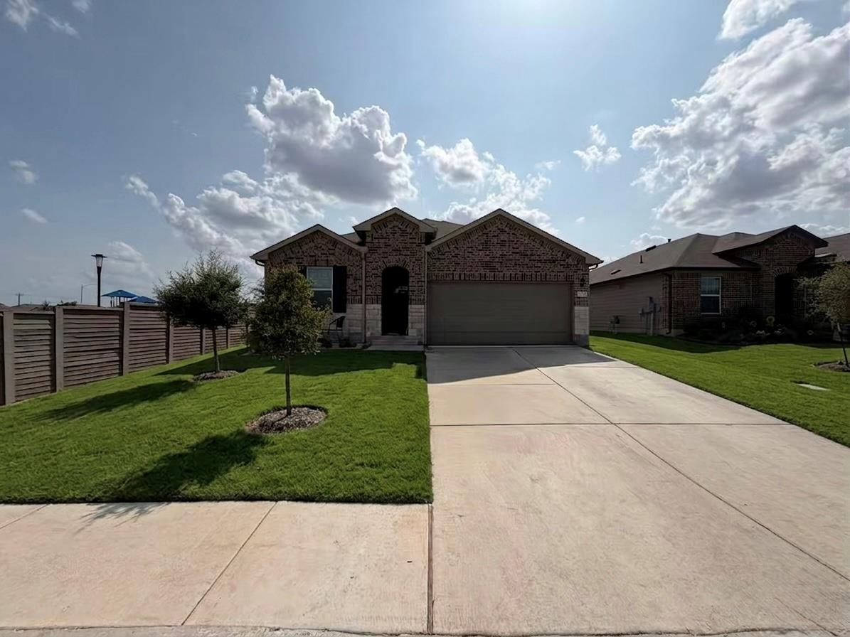 Brick exterior walls and a wide concrete driveway