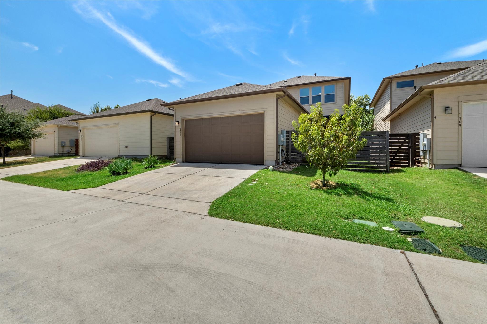 Concrete driveway leads to a modern two-story hom