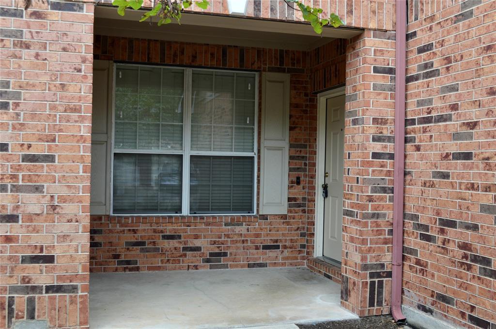 A covered concrete entryway is framed by classic 