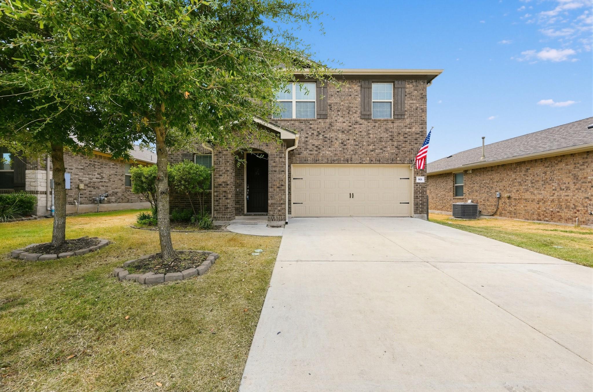 A classic brick exterior and concrete driveway le