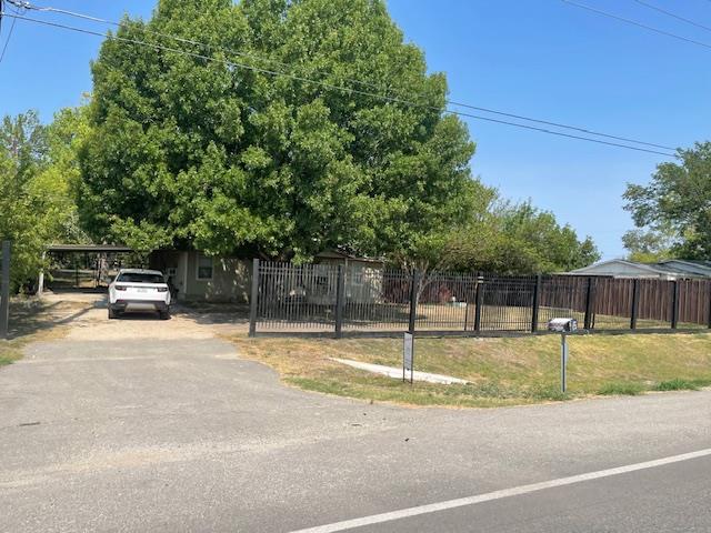 Mature trees shade a secure, fenced yard featurin