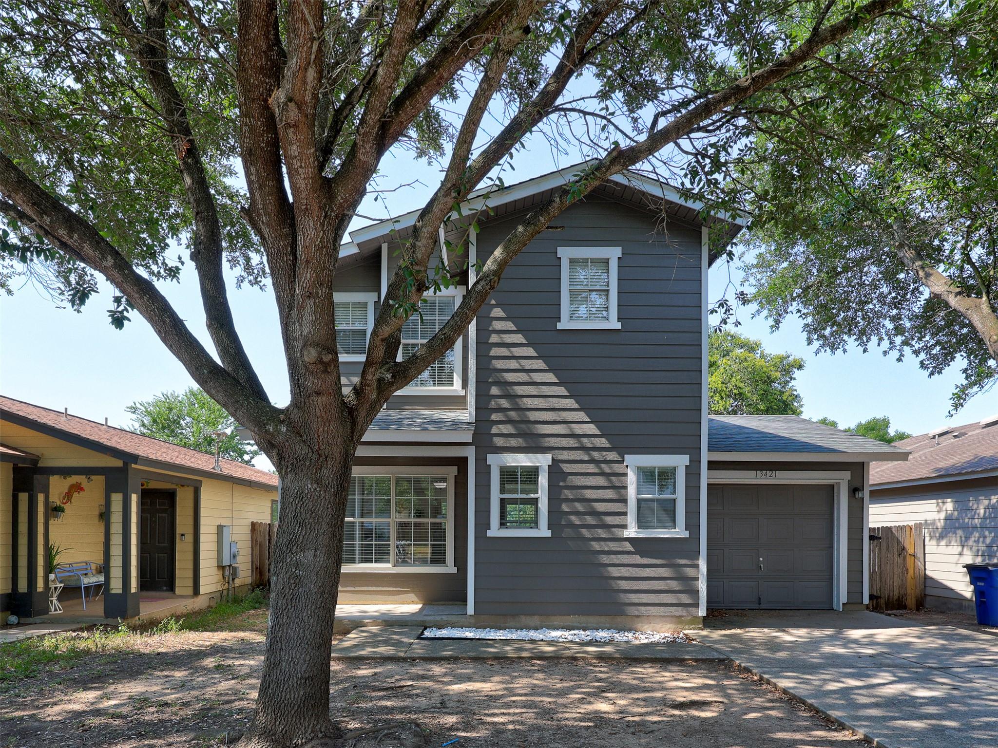 Mature trees shade the classic siding and attache