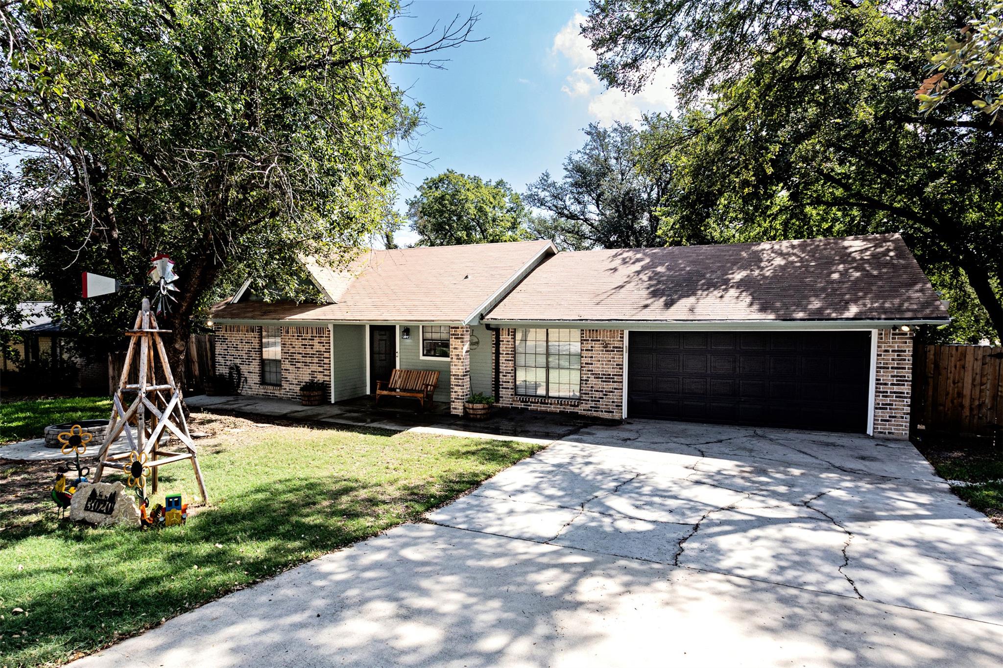 Mature trees frame this brick ranch home featurin