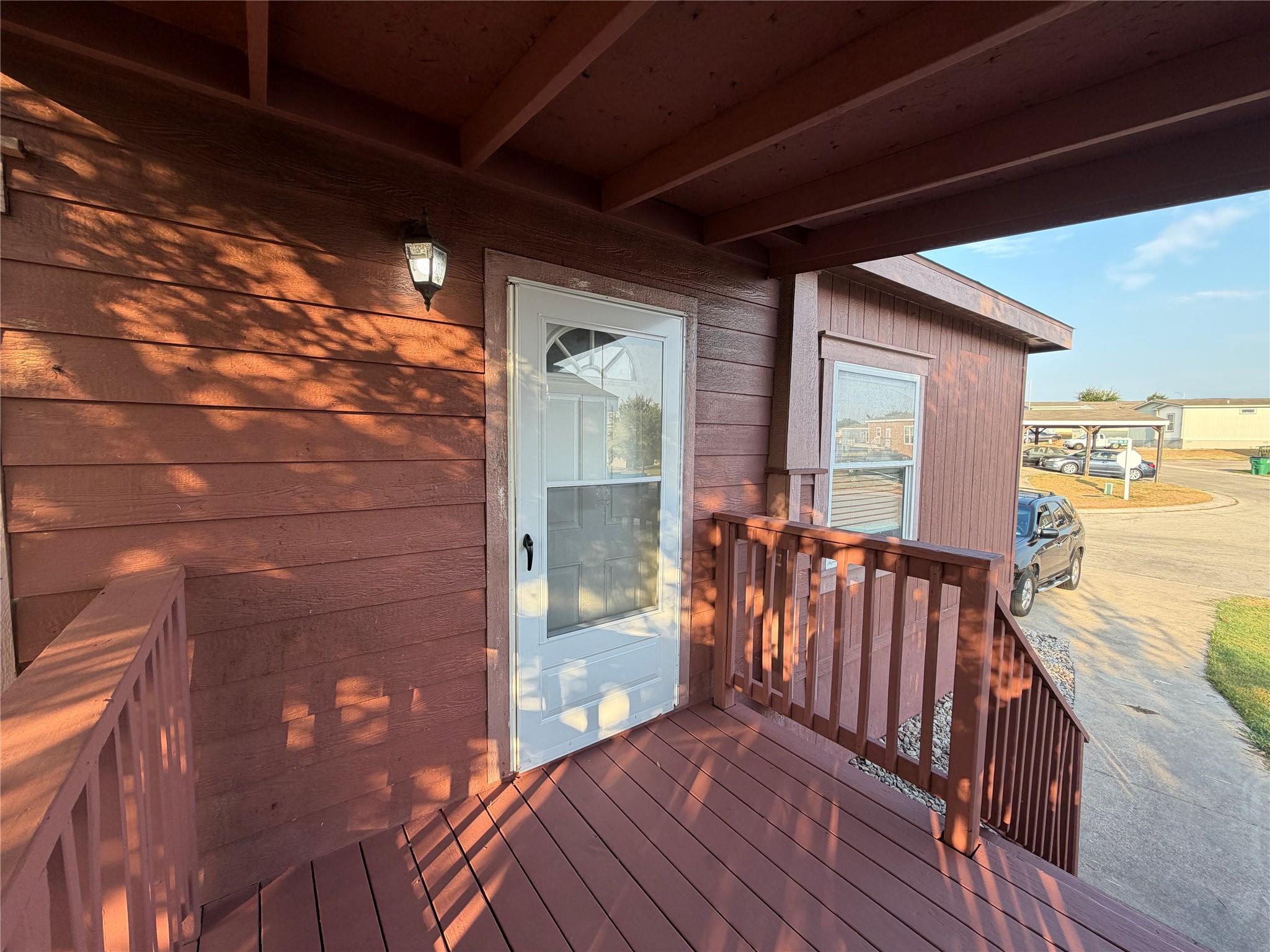 An inviting covered entry porch features wood pla