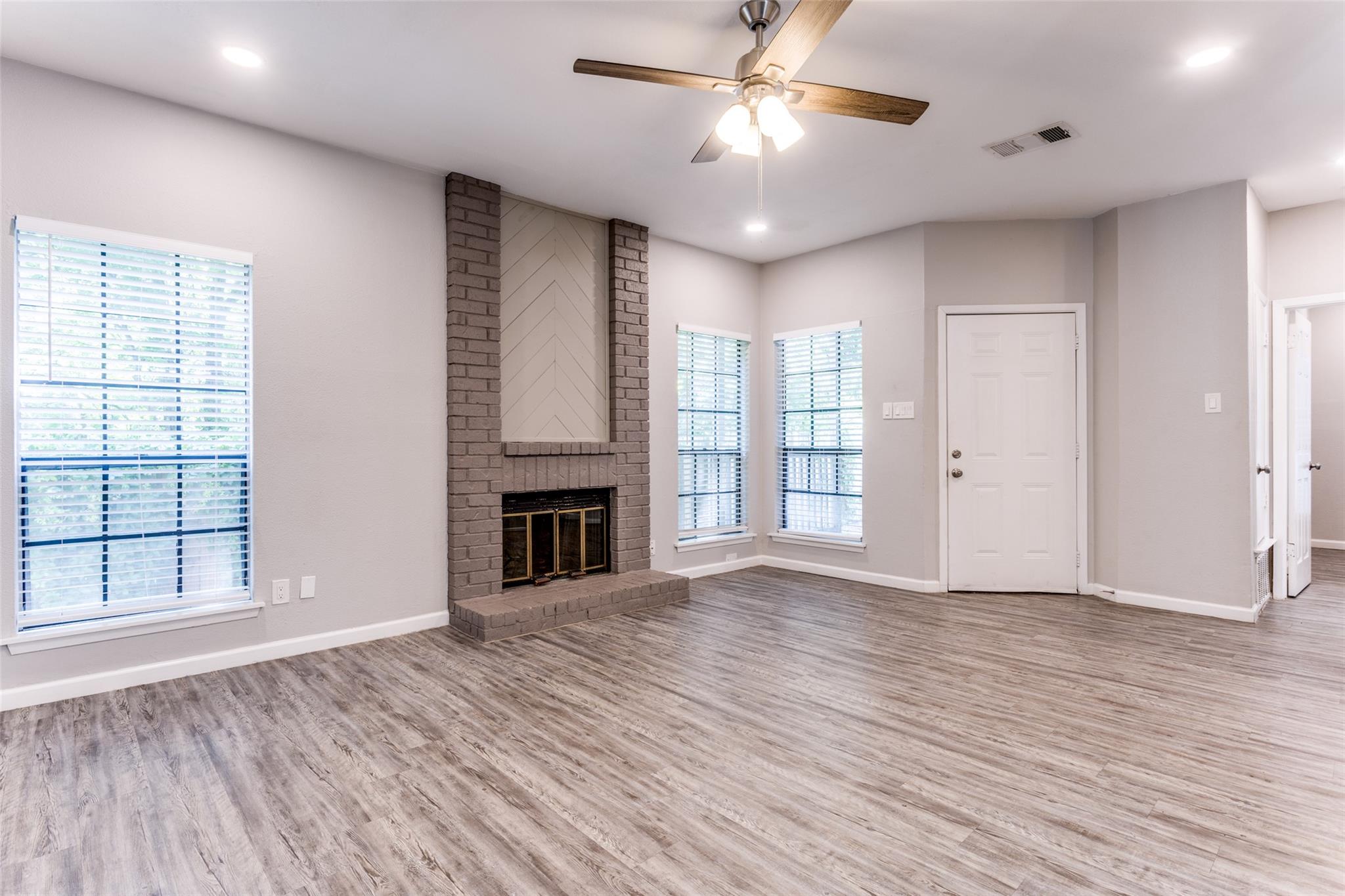 Hardwood floors and a floor-to-ceiling brick fire