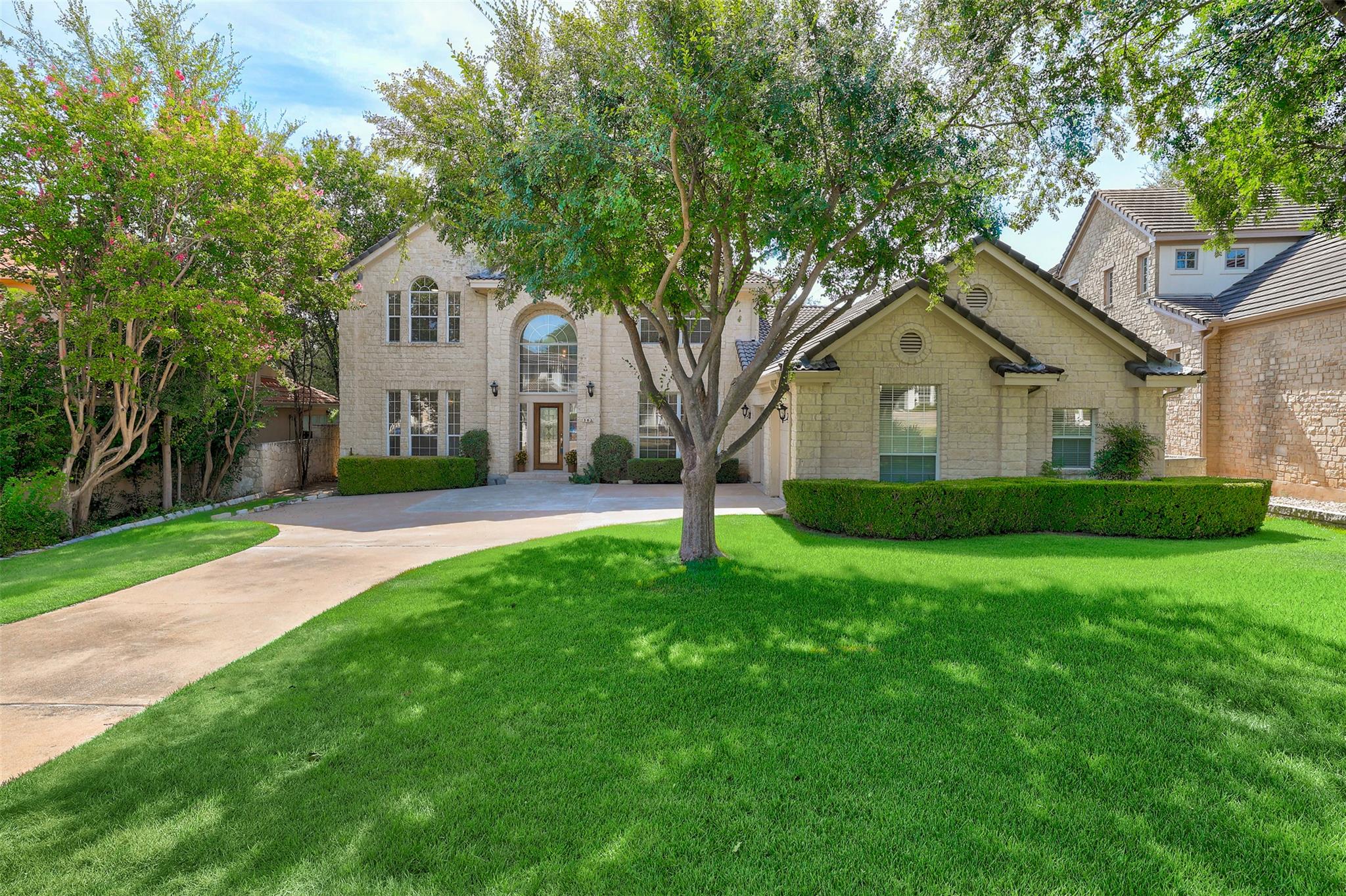 Established shade trees and a manicured lawn fram
