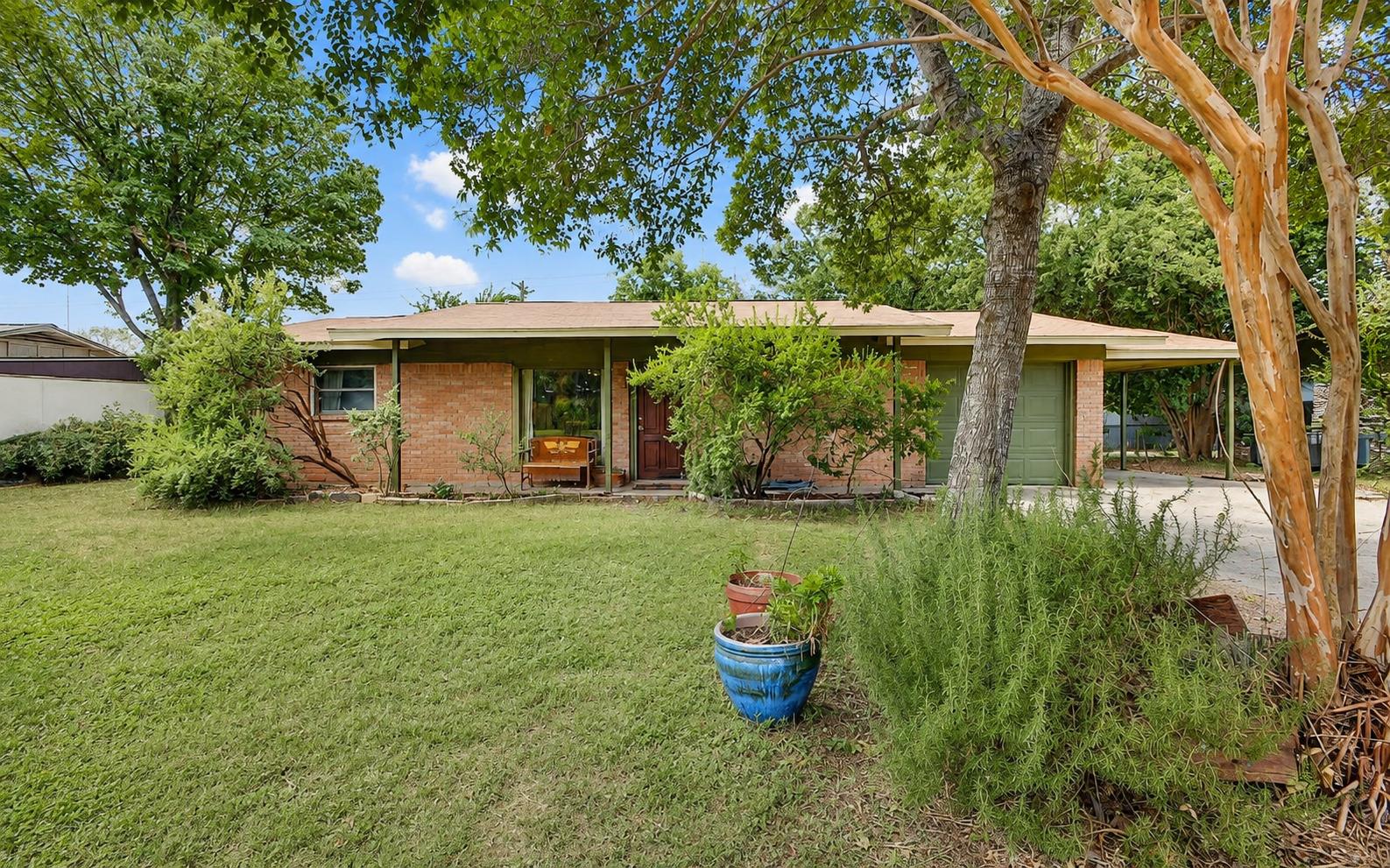 Mature trees shade the lawn of this classic singl