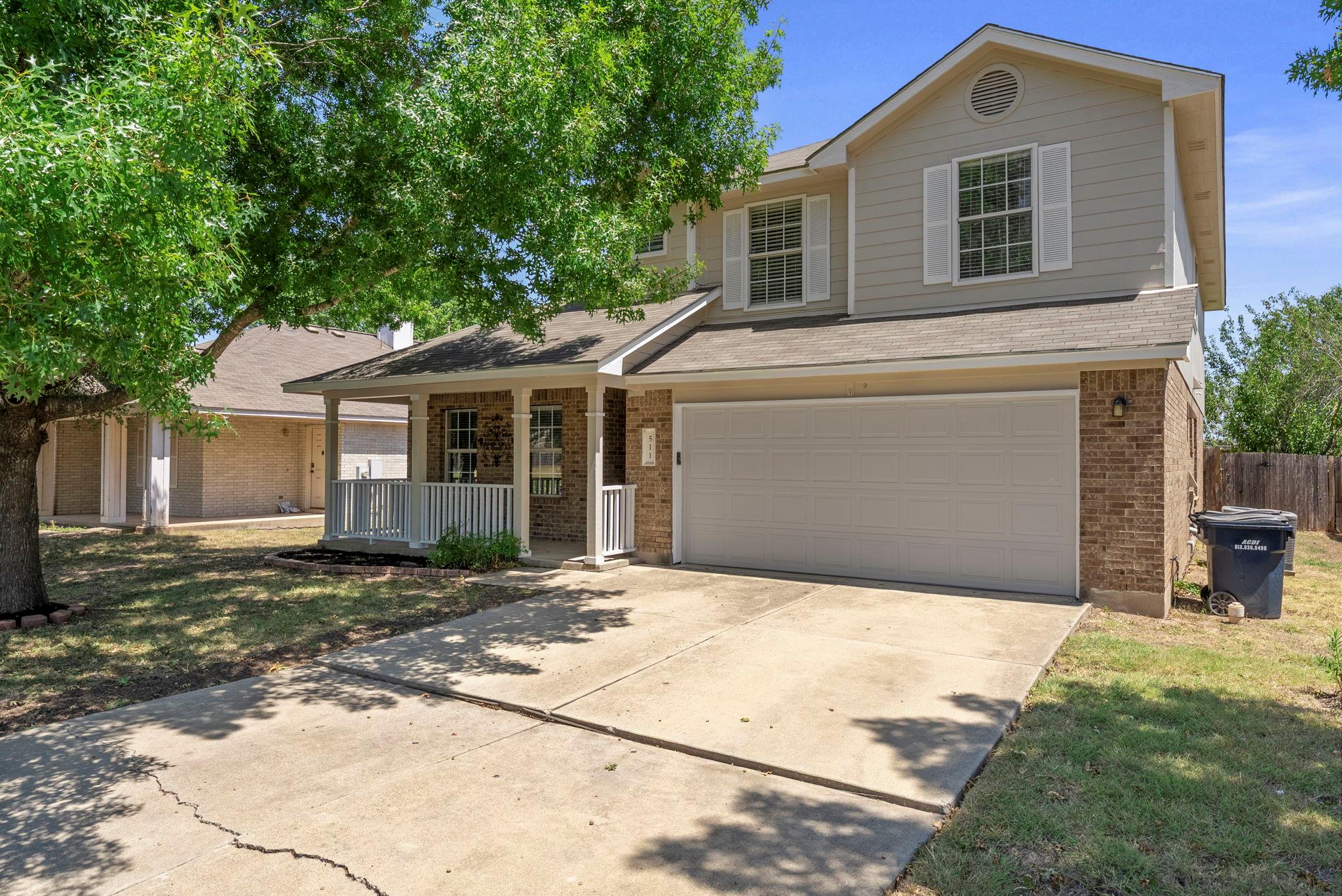 Mature trees shade a welcoming front porch and co