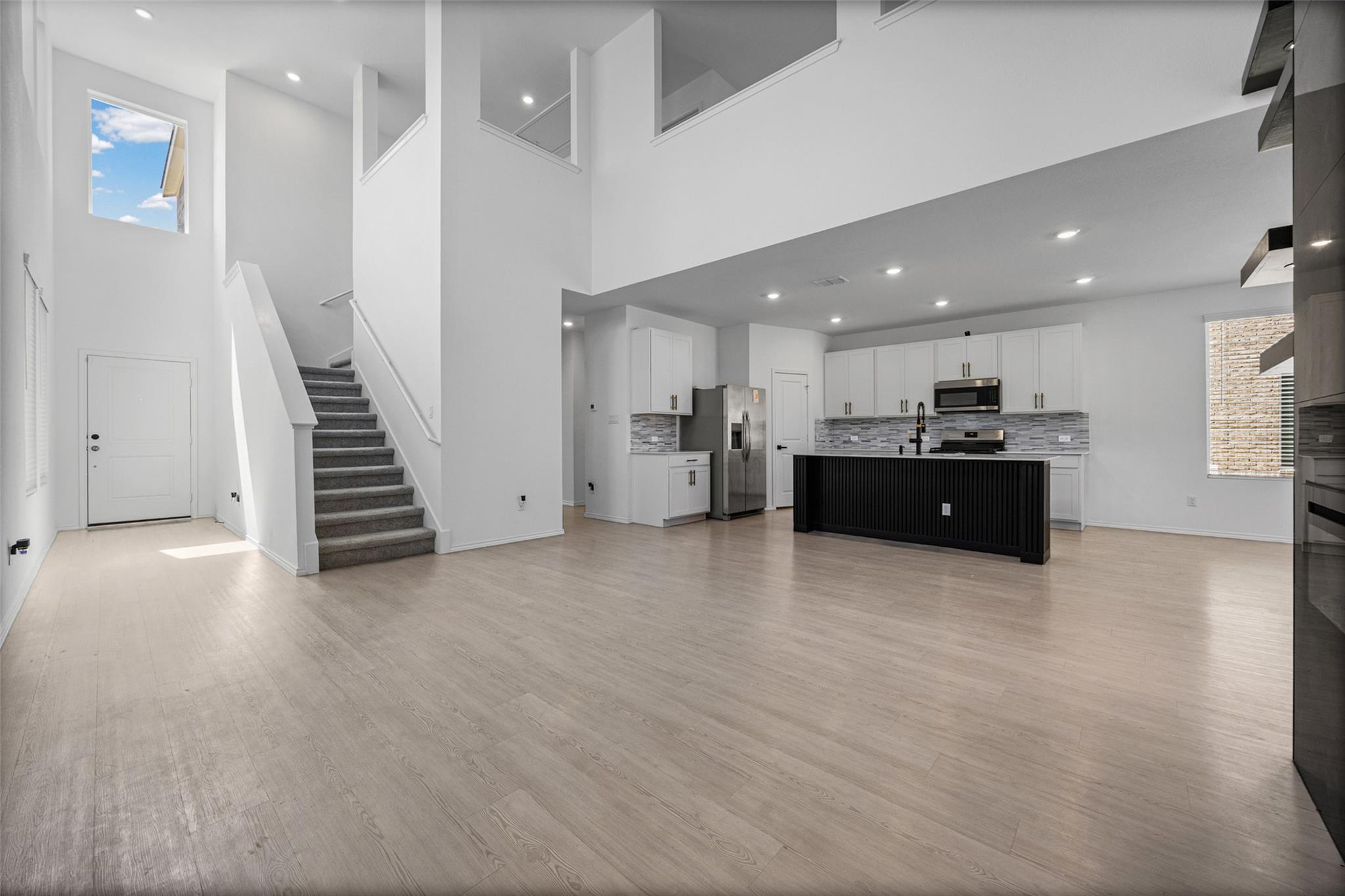 Double-height ceilings and light wood floors defi