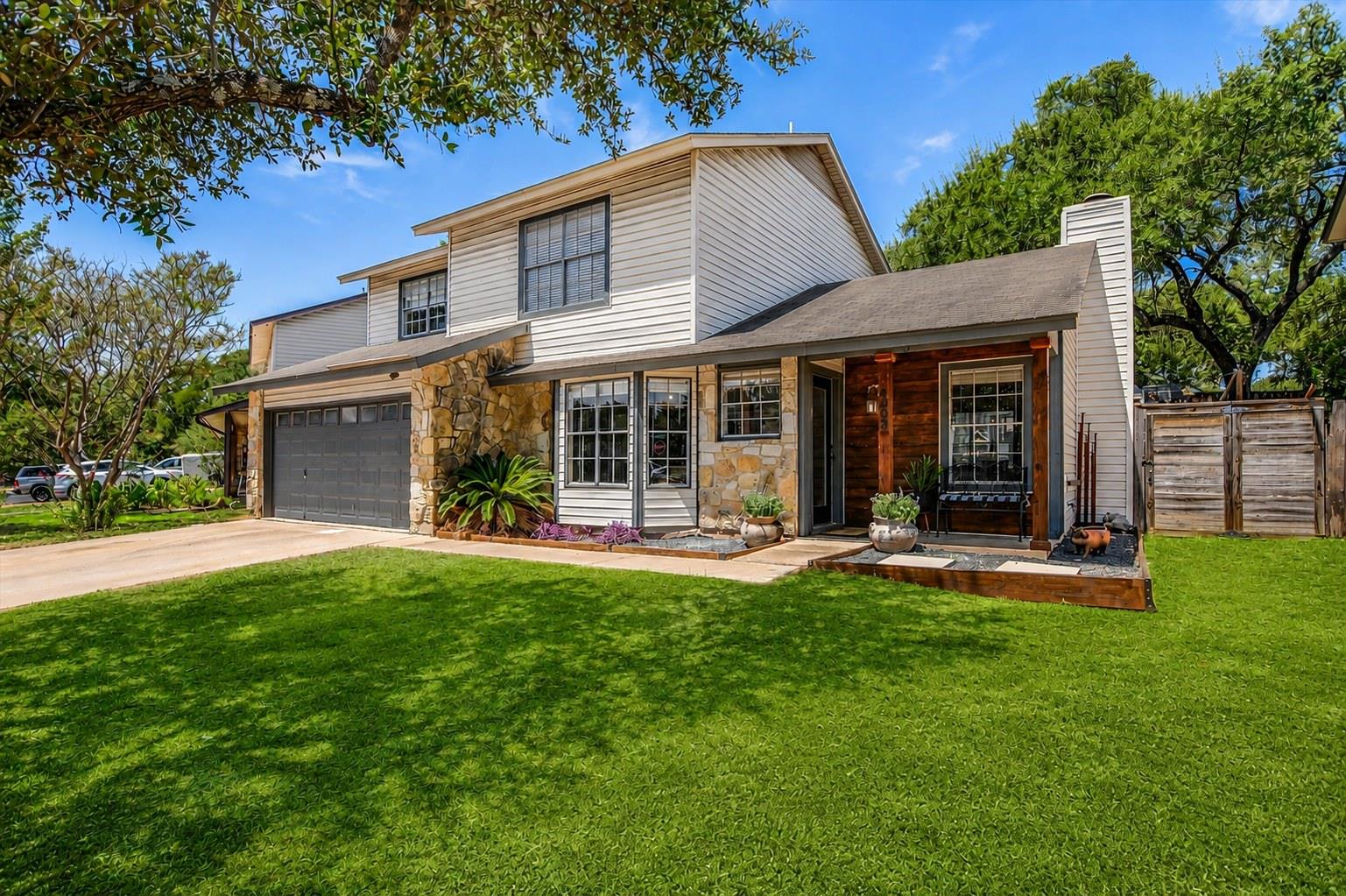 Mature trees shade a manicured lawn leading to th