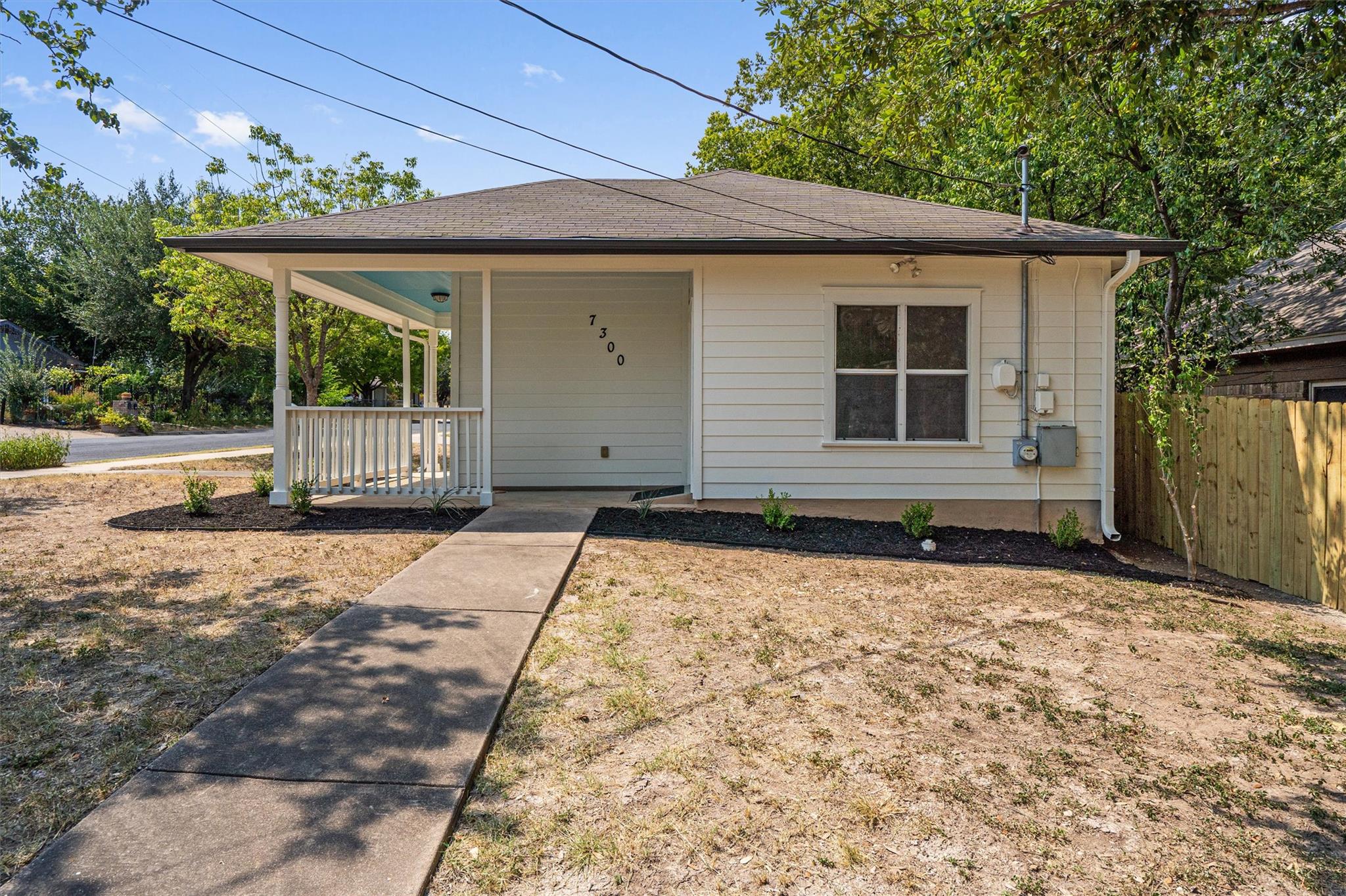 A concrete walkway leads to the inviting front po