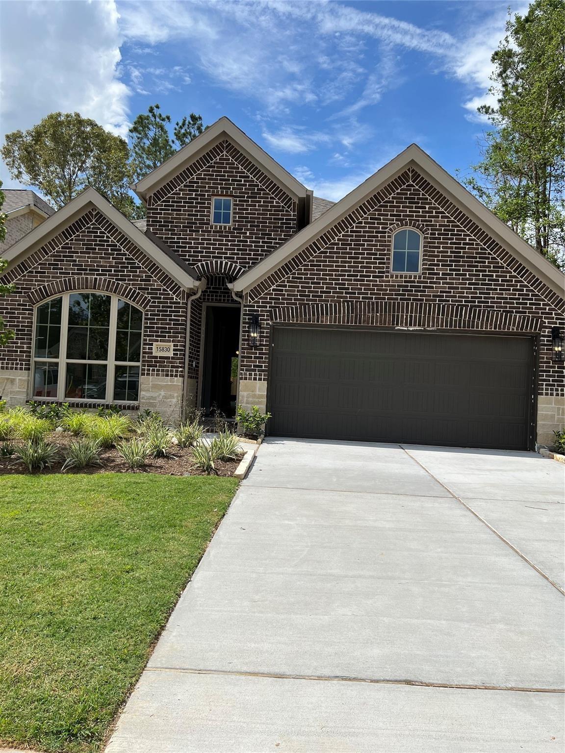 View of front facade with a garage, concrete driv