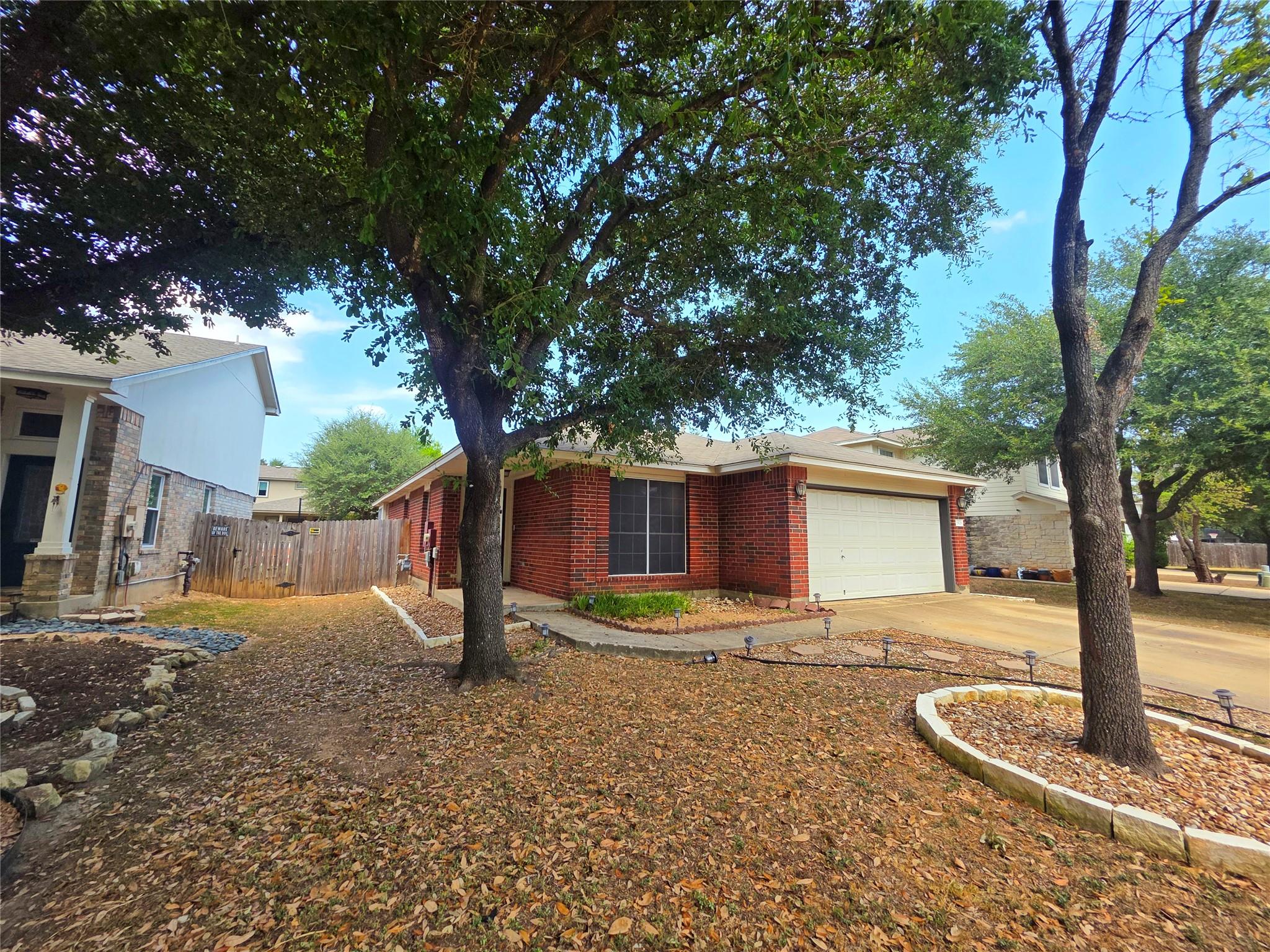Mature trees shade the brick exterior and attache
