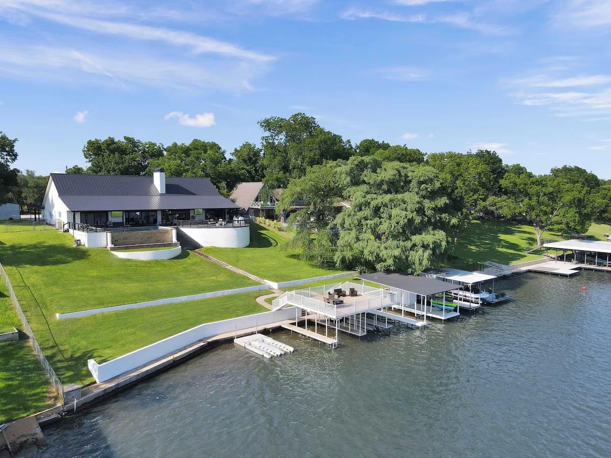 Lawn slopes gently toward a private dock and a sp