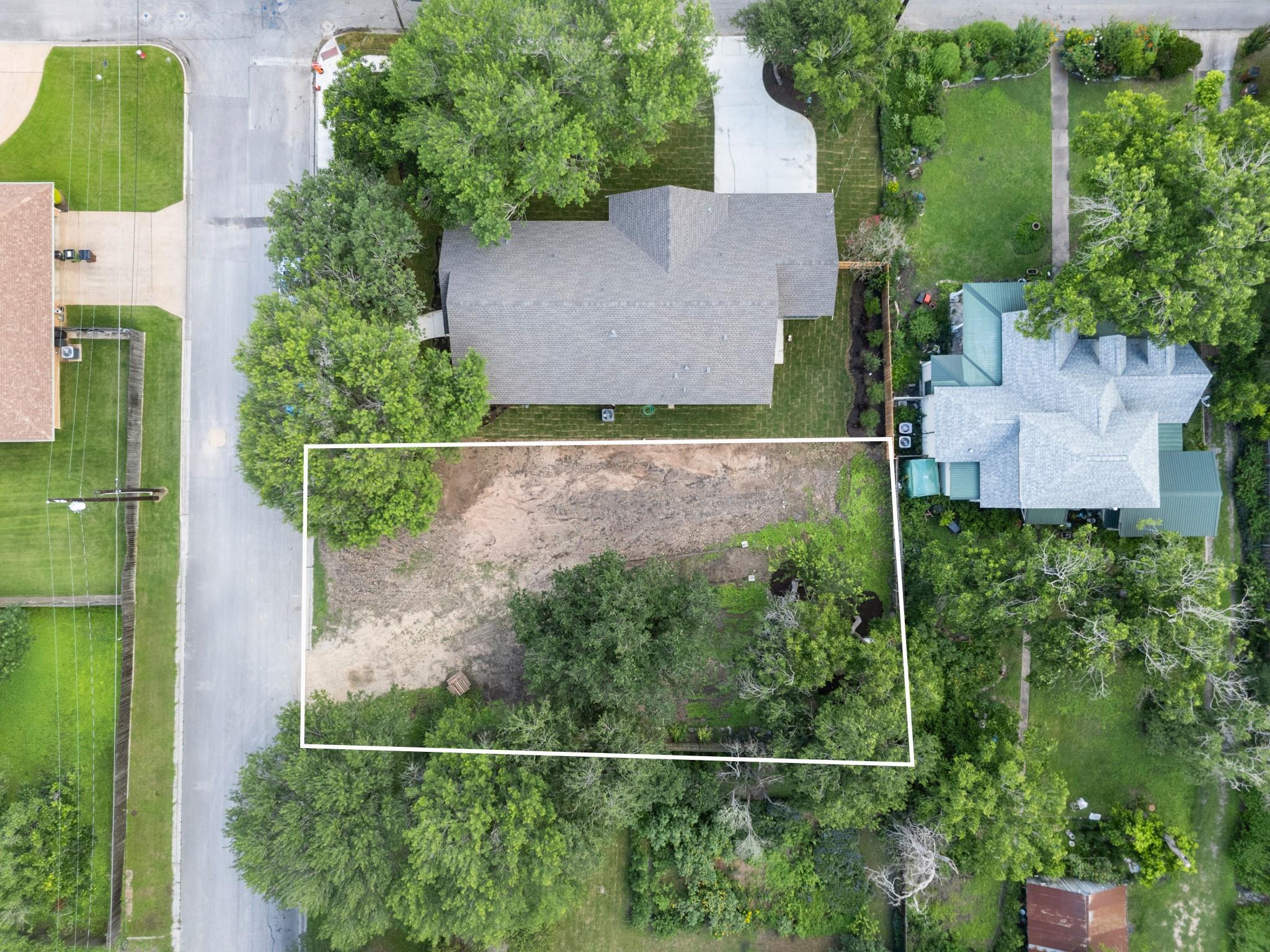 Mature trees frame a spacious building site outli