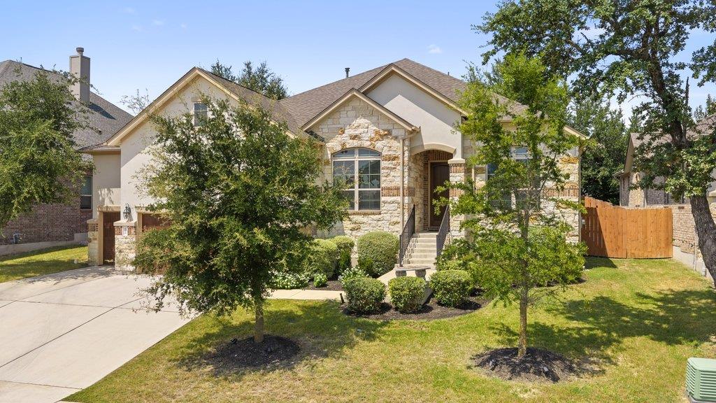 Mature trees frame a classic stone and stucco fac