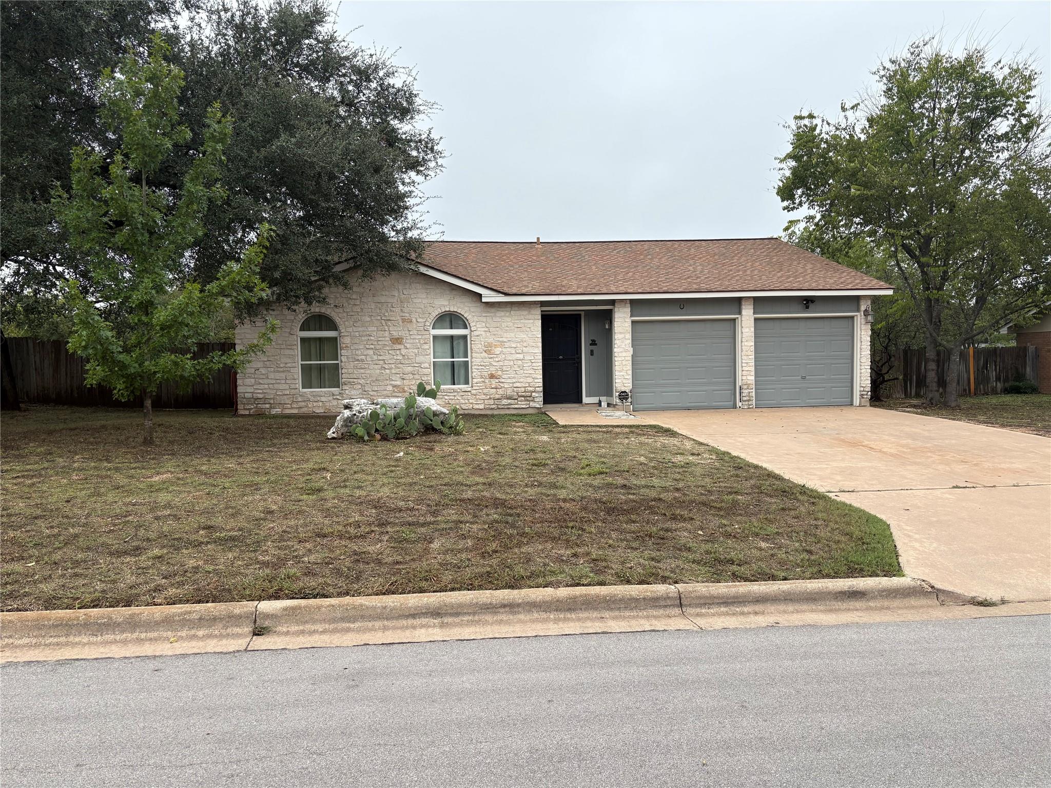A classic stone exterior and concrete driveway fr