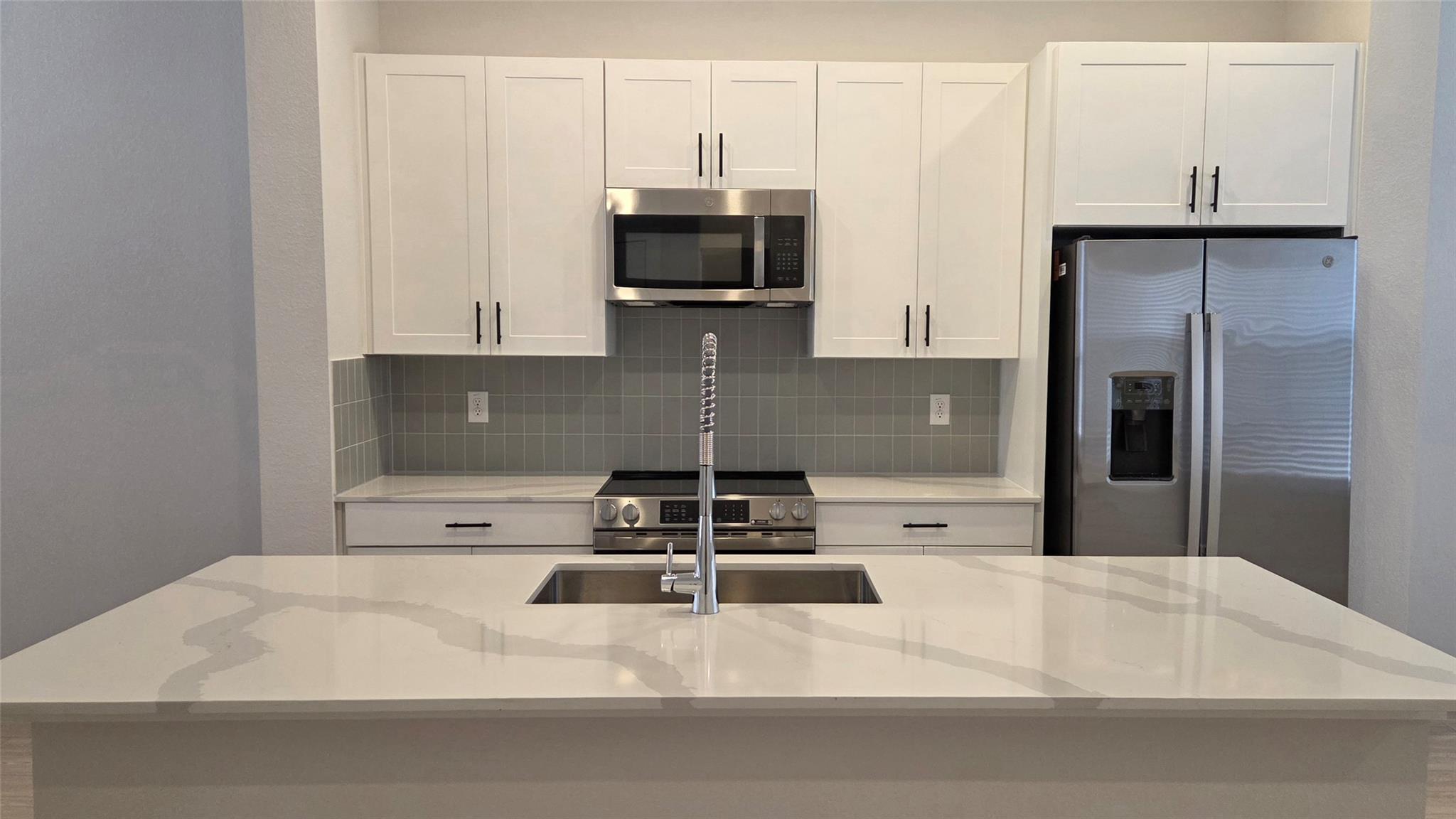 Sleek stone countertops and modern cabinetry defi