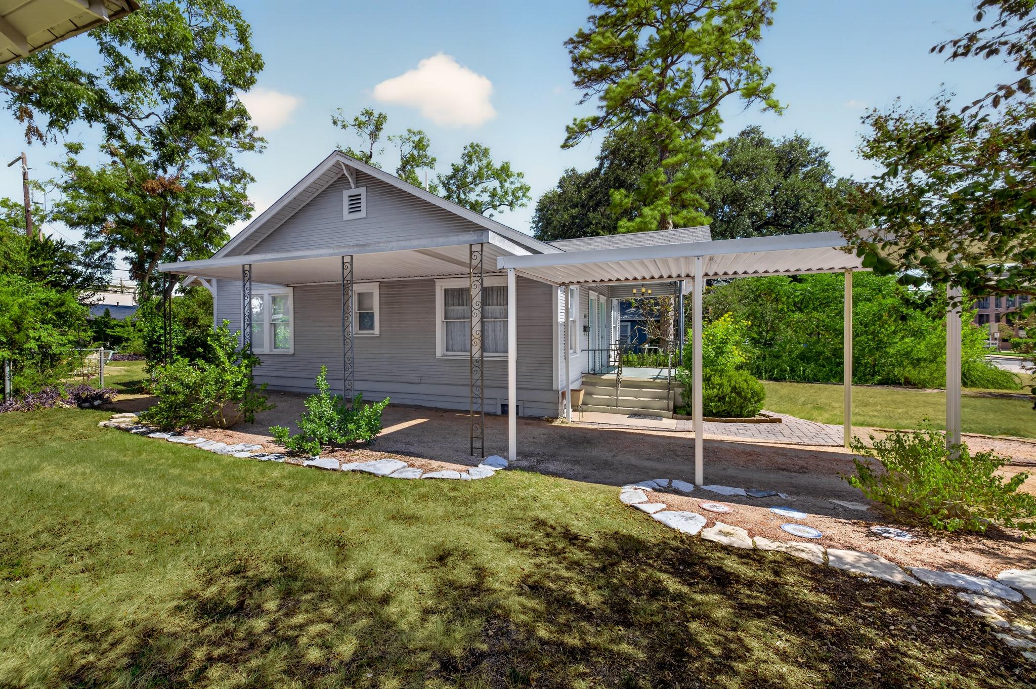 Mature trees frame a classic single-story exterio