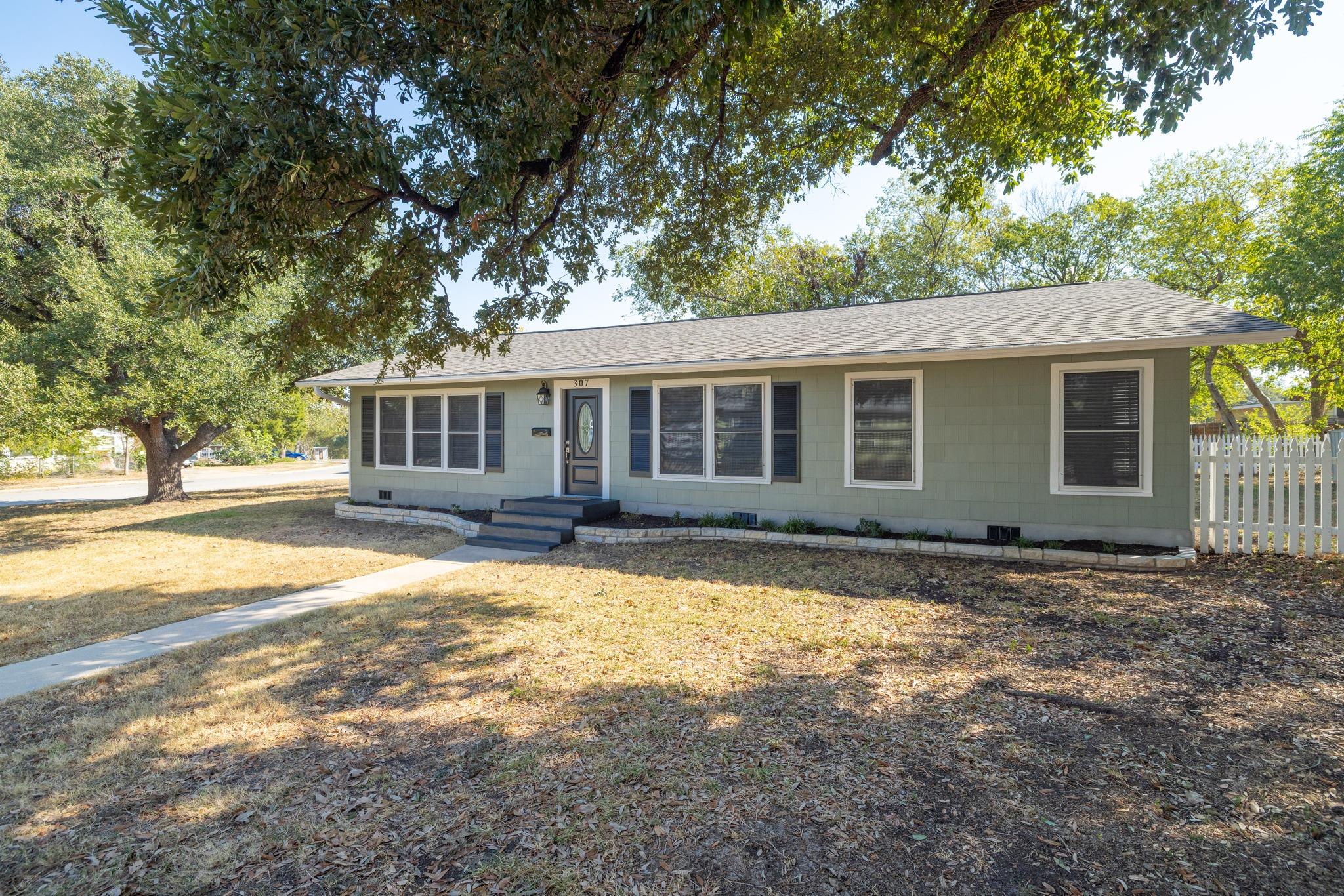 Mature trees shade the front lawn of this single-