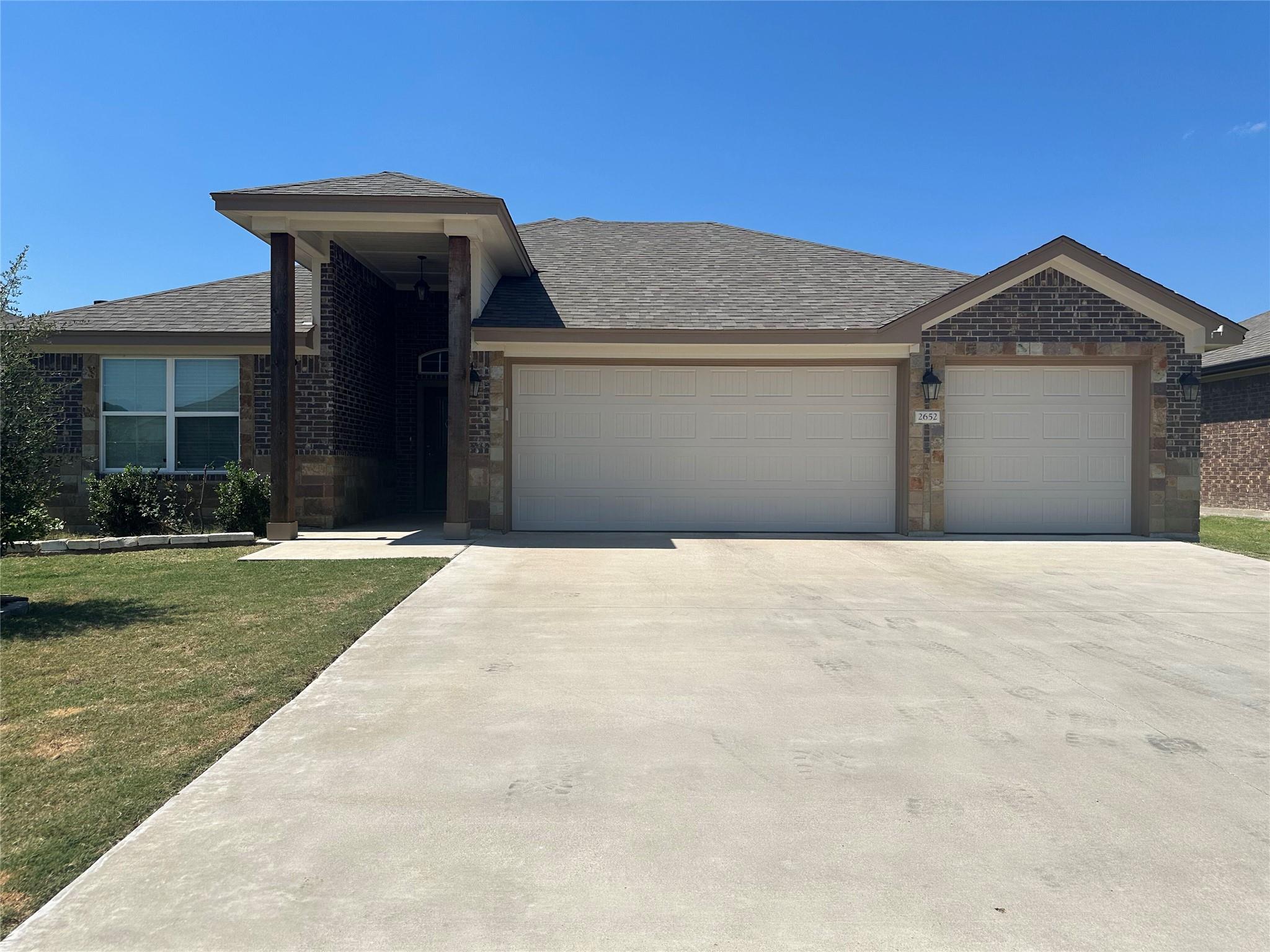 A spacious concrete driveway leads to a prominent