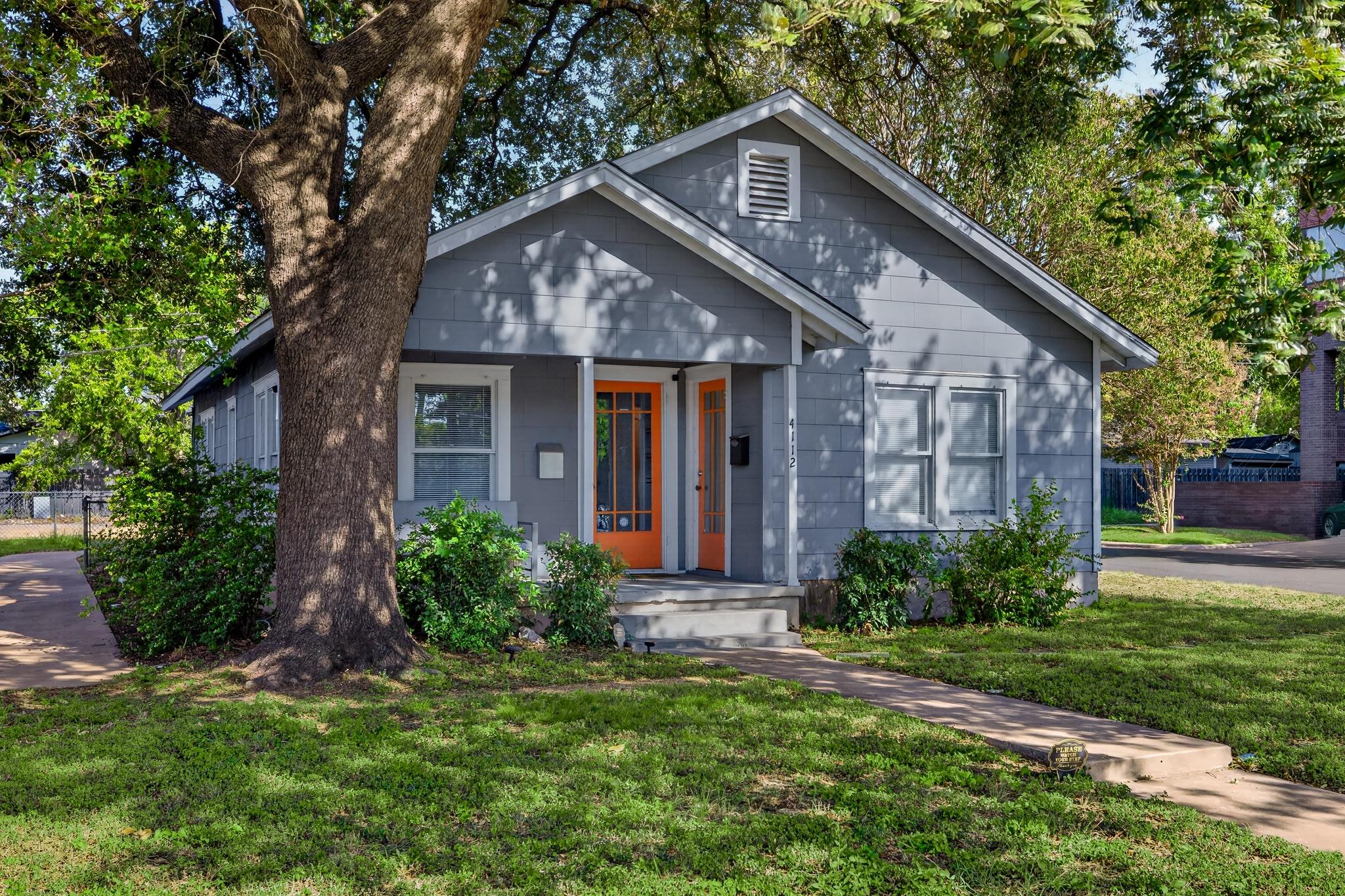 Mature shade trees frame a charming classic cotta