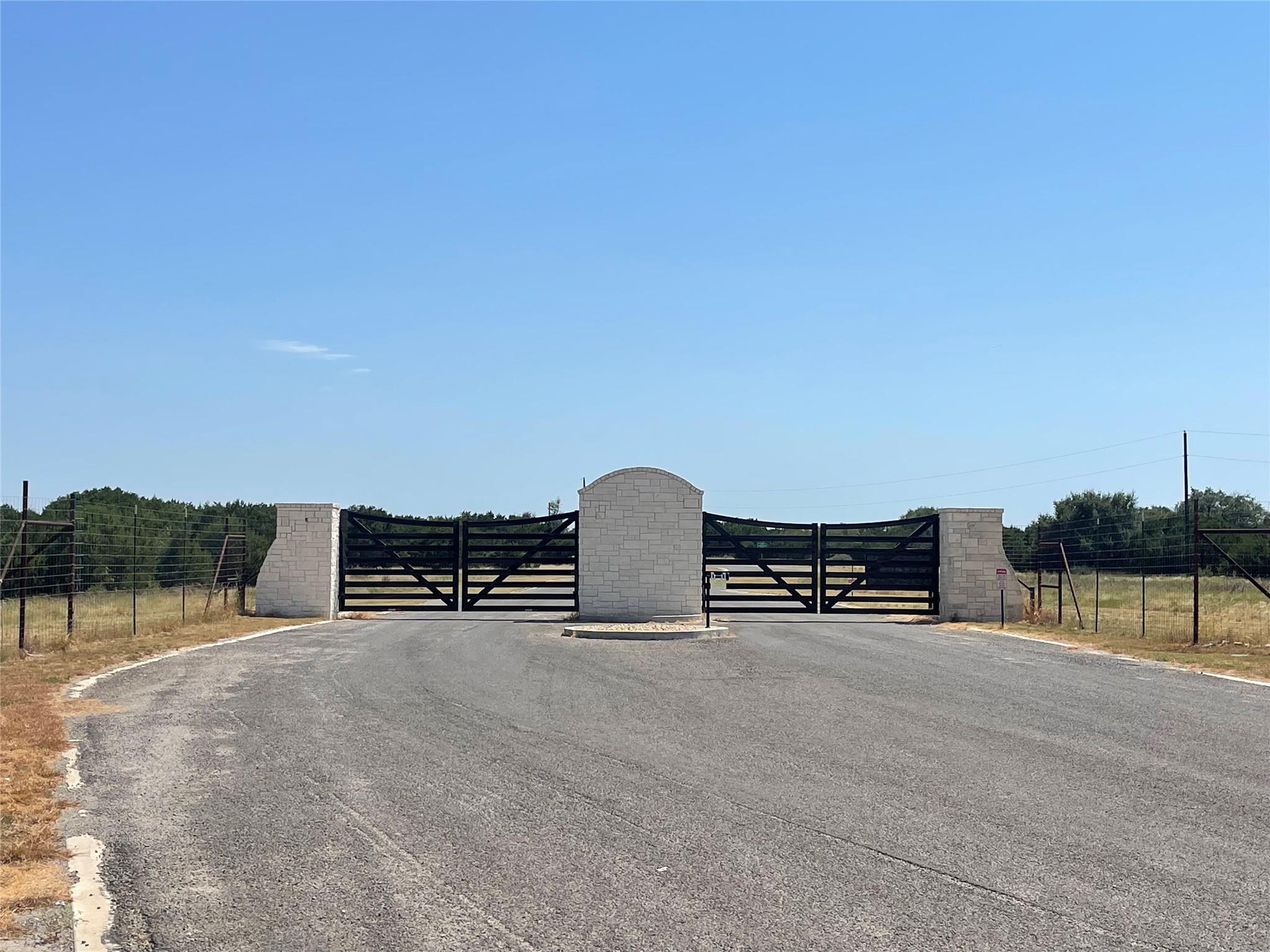 Secure gated entry features stone pillars under a