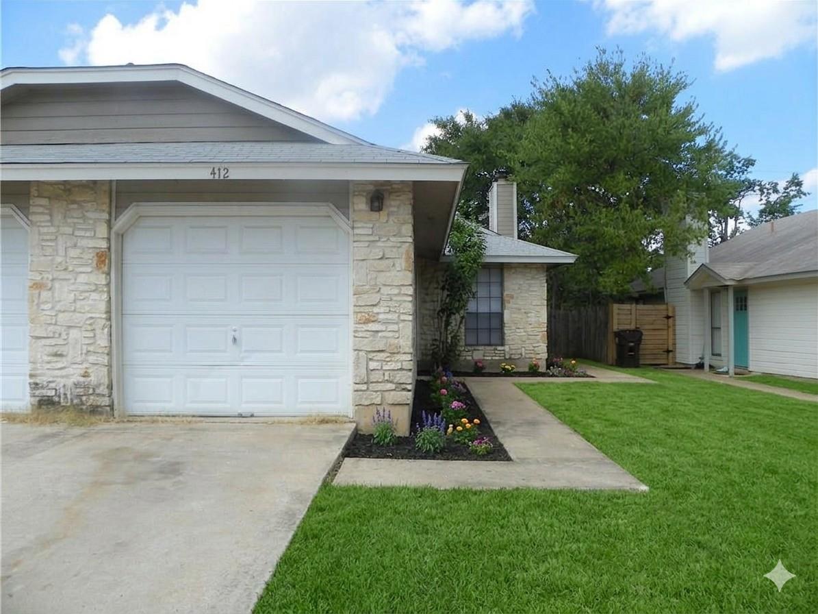 Textured stone accents and a manicured lawn frame