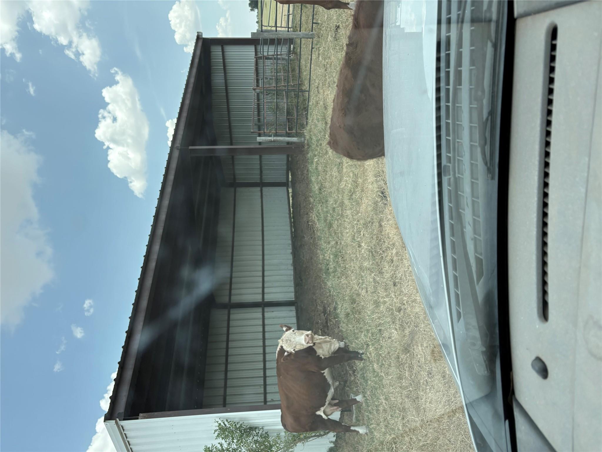 An open metal pole barn provides functional shelt