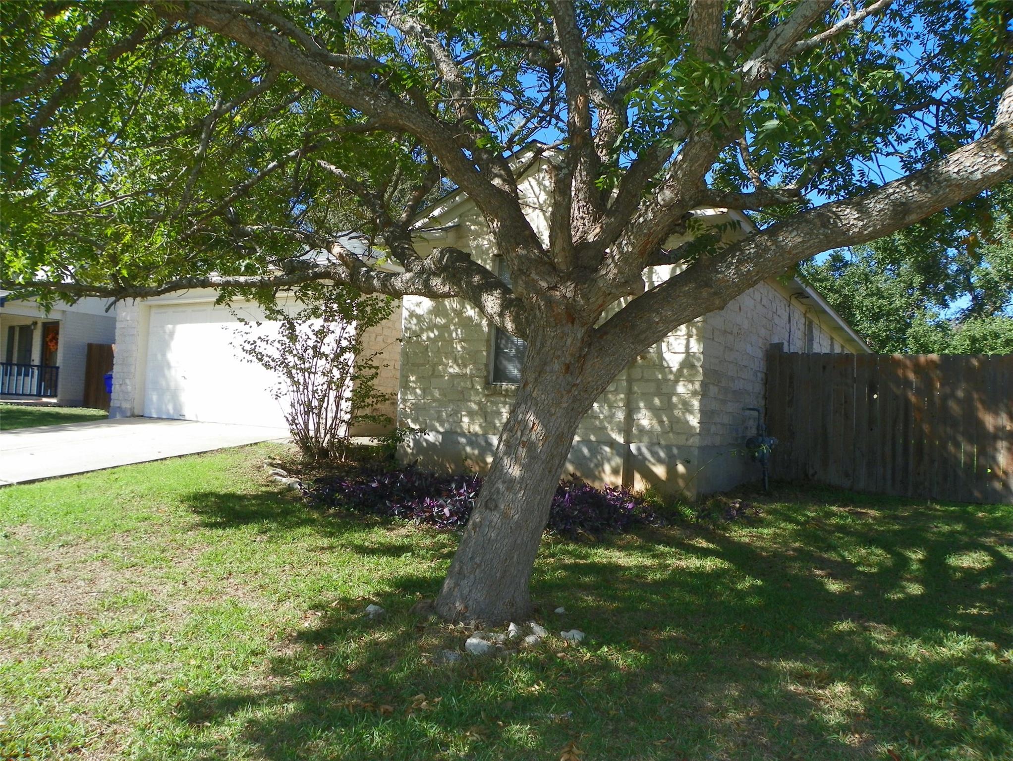 Mature trees shade a classic stone exterior with 