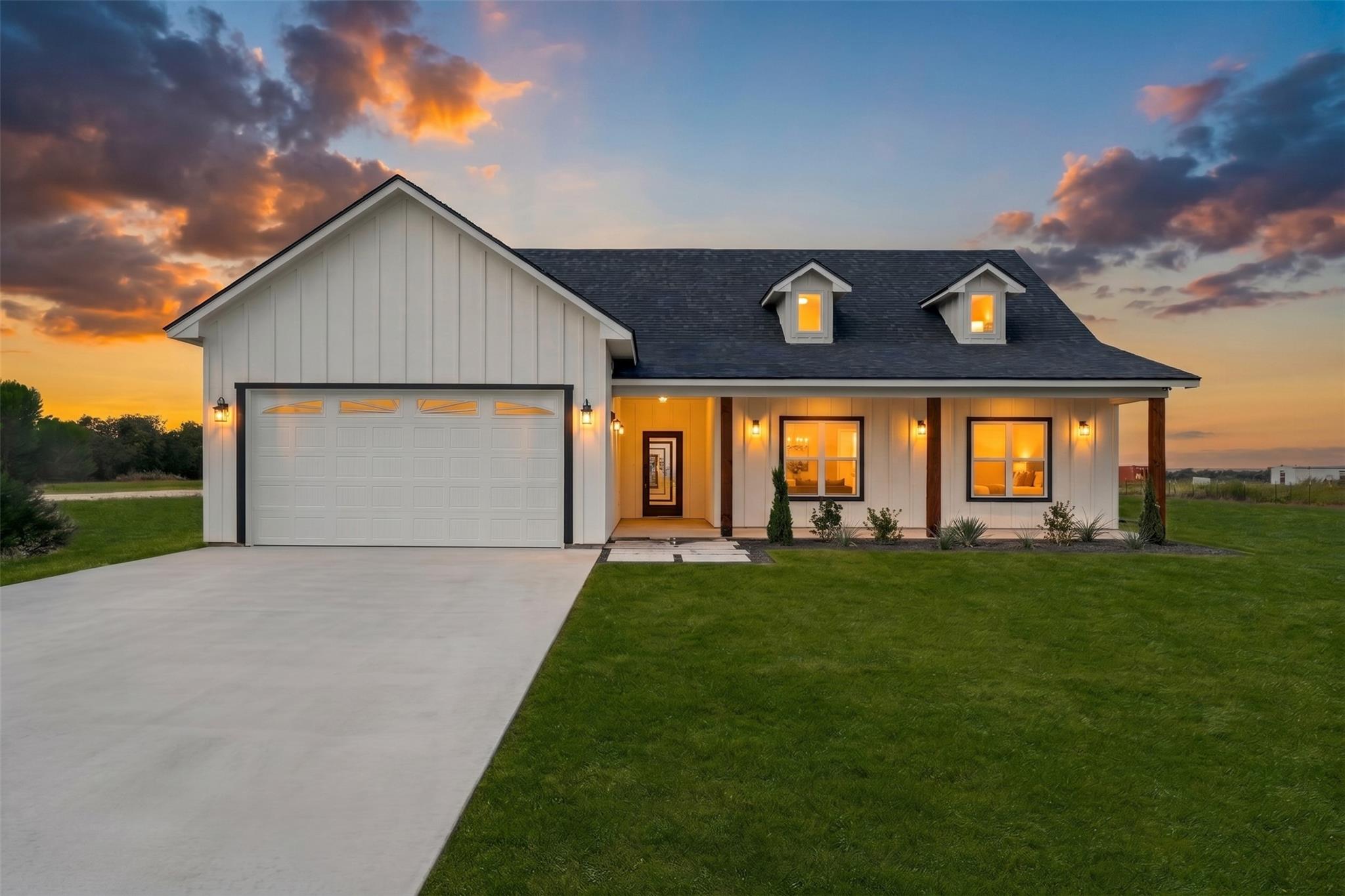 A crisp concrete driveway leads to a modern farmh
