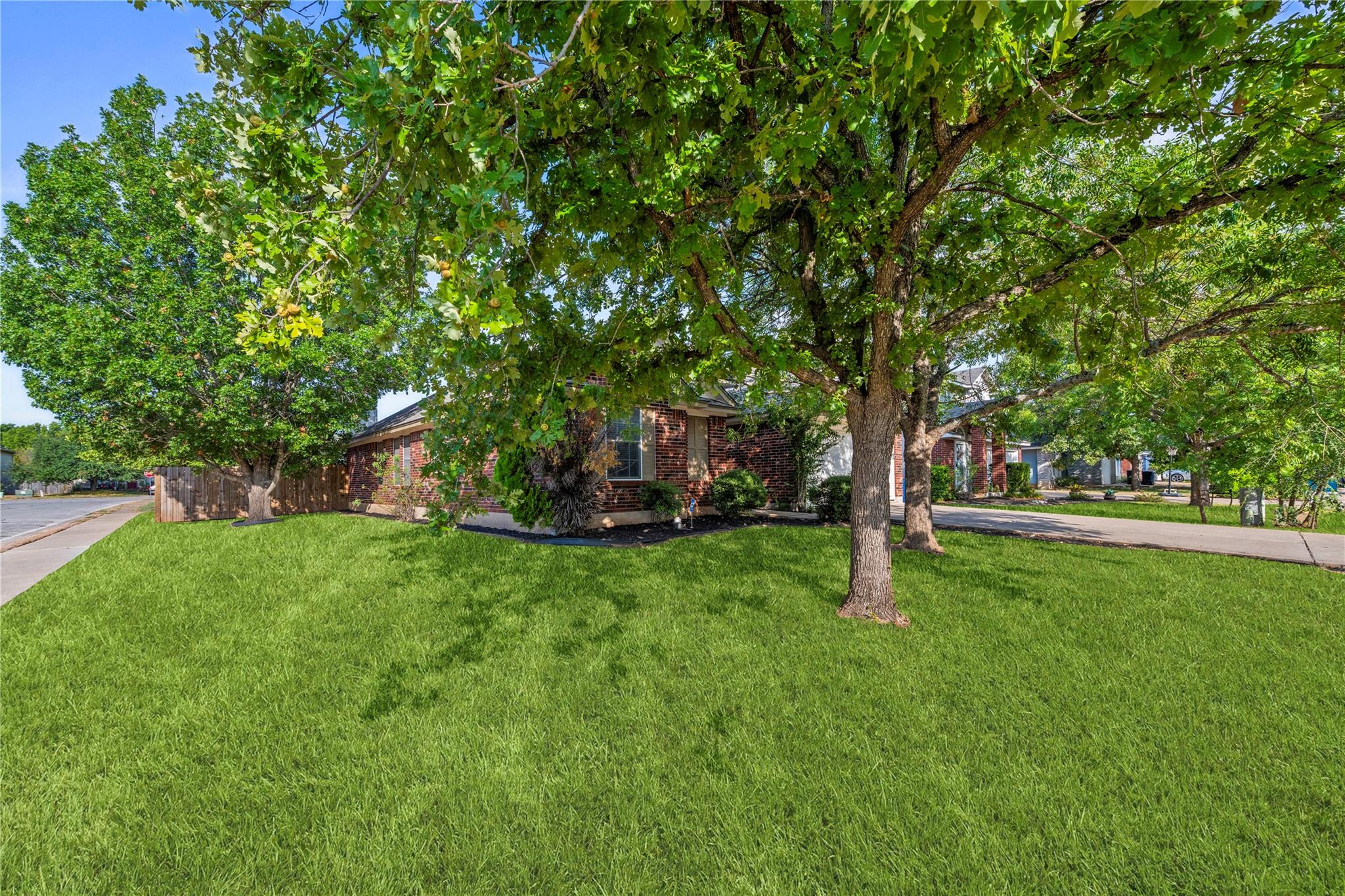 Mature trees shade a spacious green lawn leading 