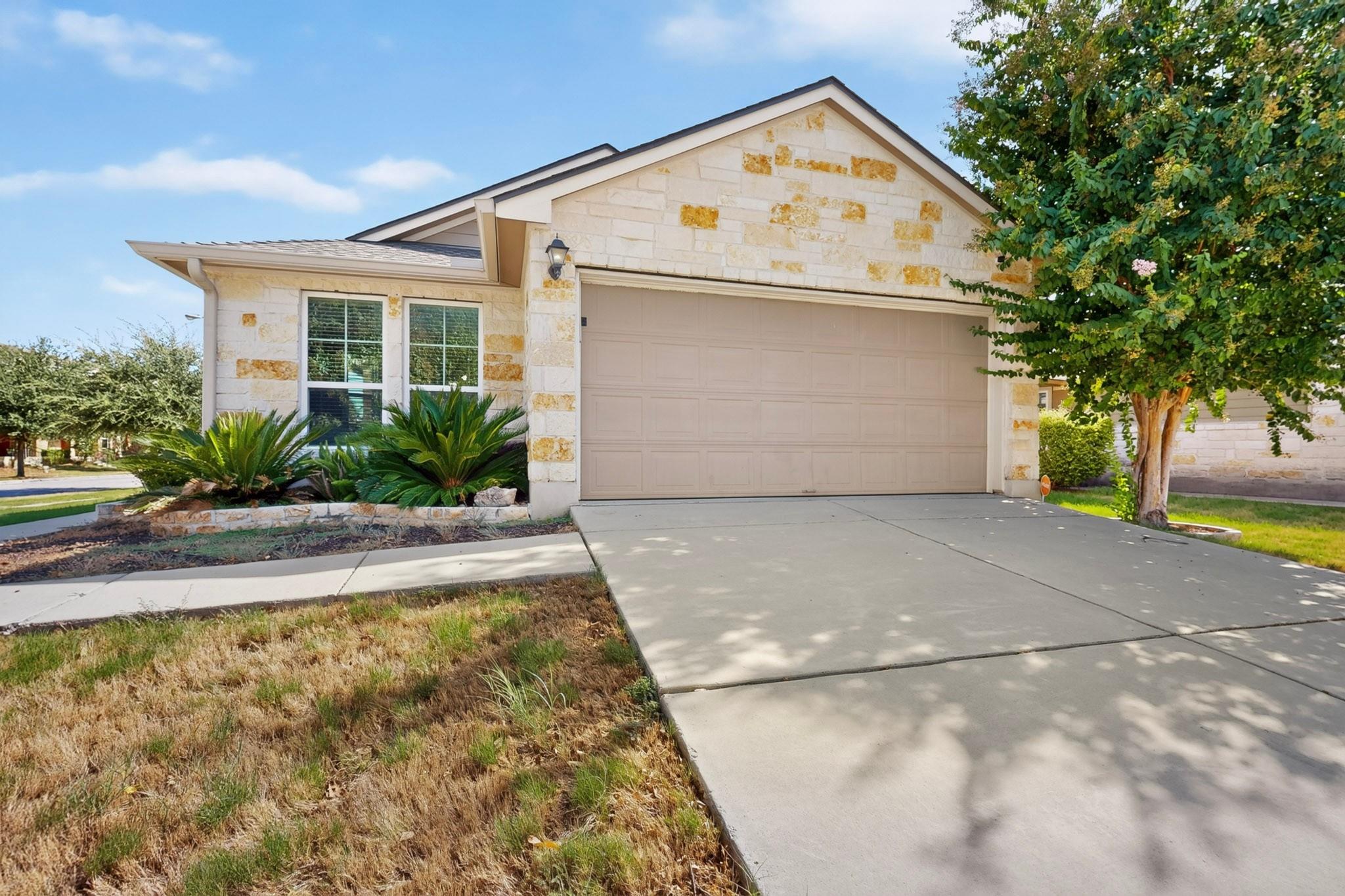Natural stone masonry and a wide concrete drivewa